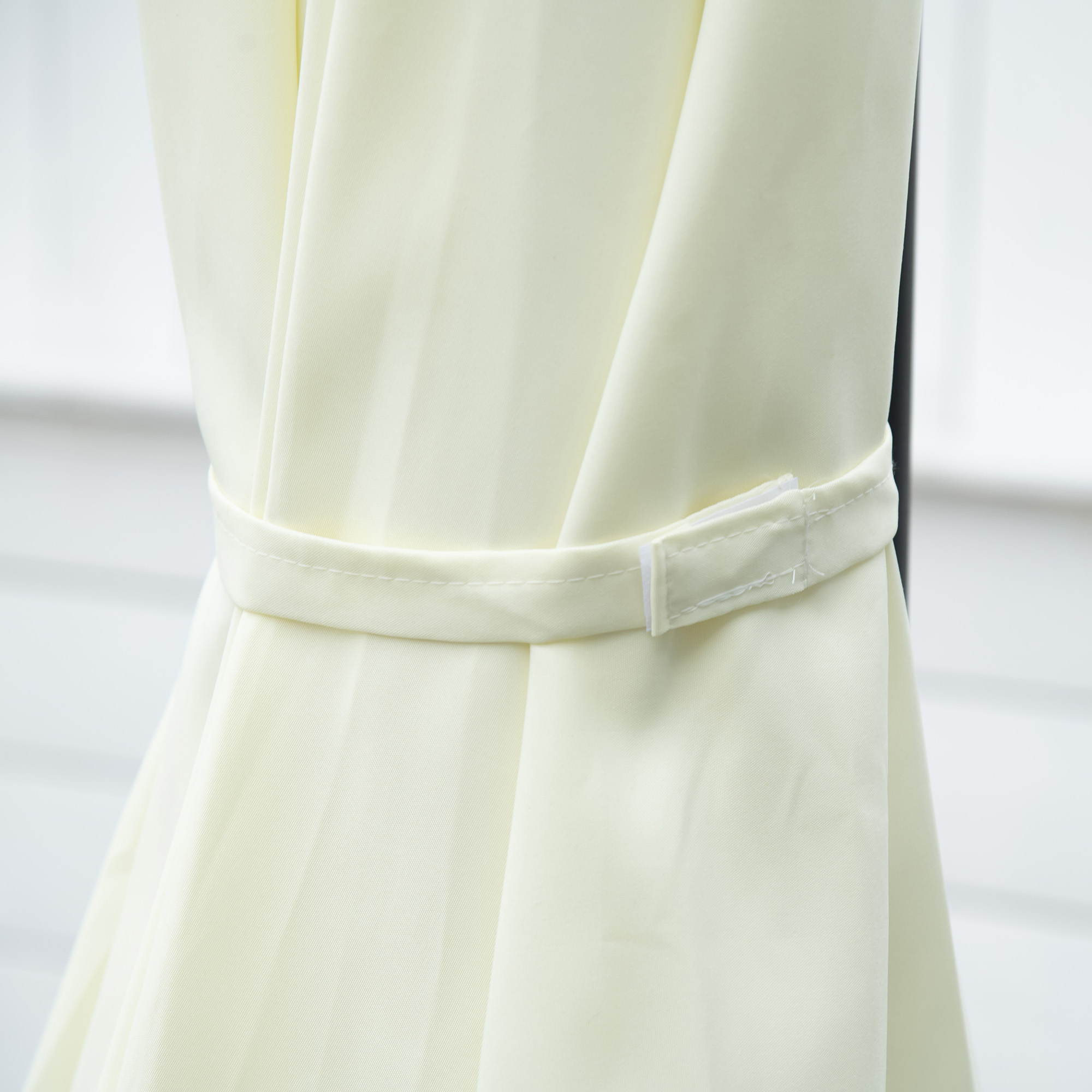 Tessuto giallo chiaro con cinturino in velcro bianco che lo tiene insieme.