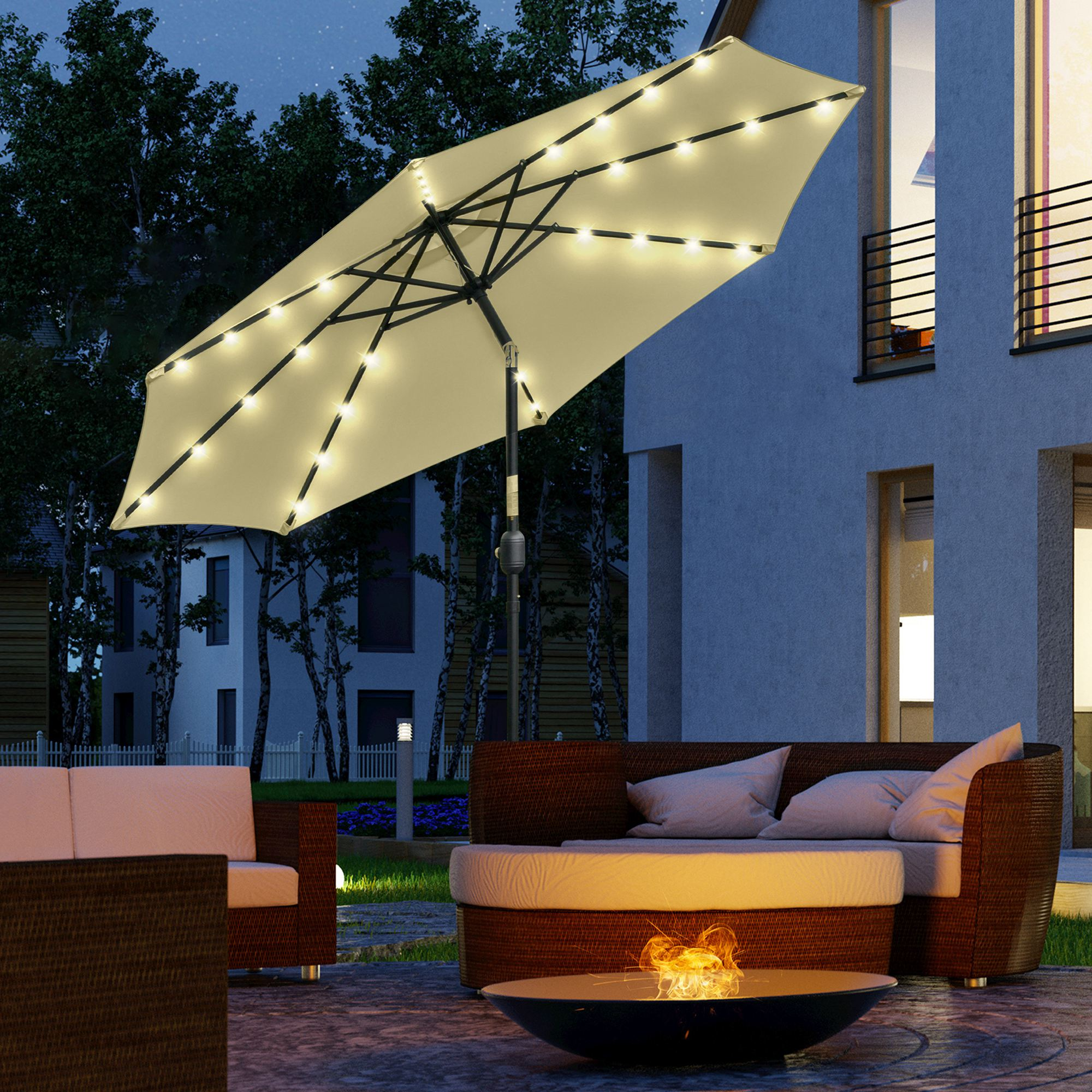 Un ombrellone illuminato su un set da giardino con braciere di notte.