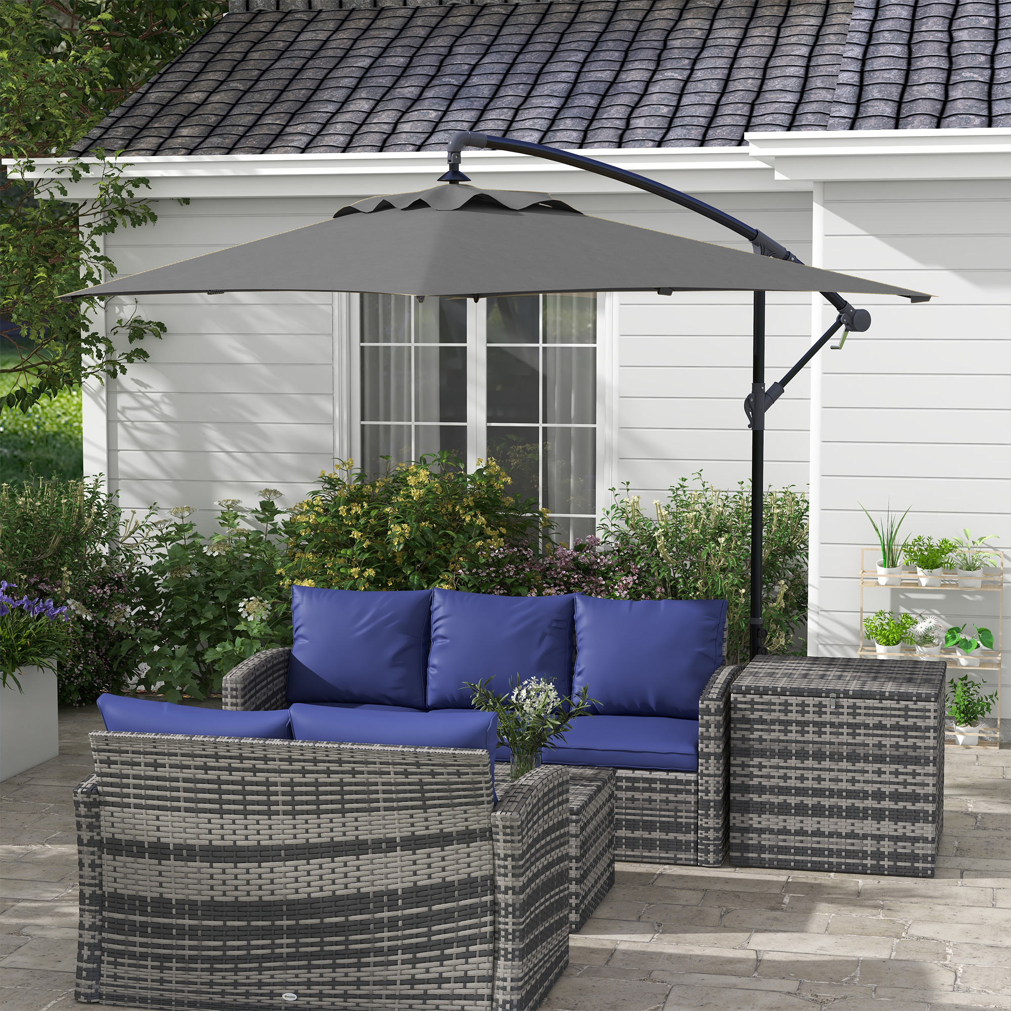 Mobili da esterno in rattan grigio con cuscini blu e ombrellone.