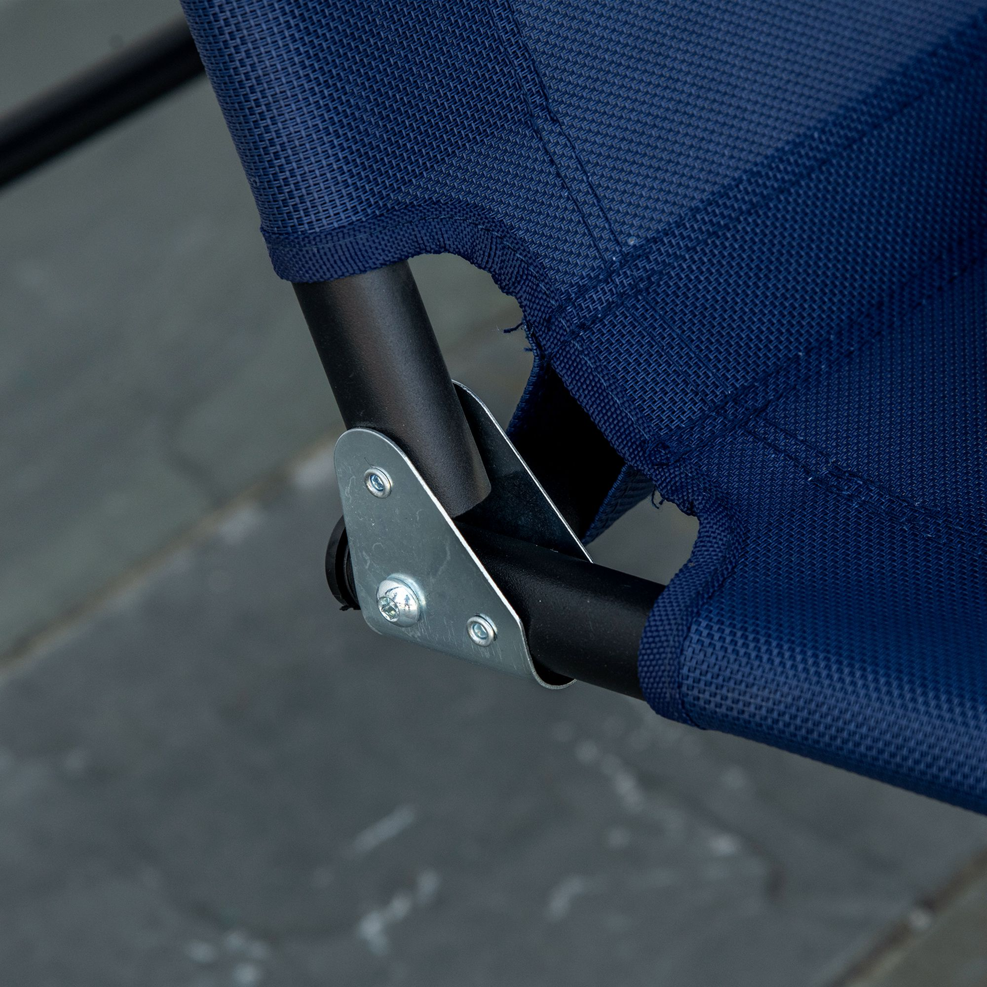 Primo piano di una sdraio in tessuto blu con supporti in metallo nero e staffa argentata.