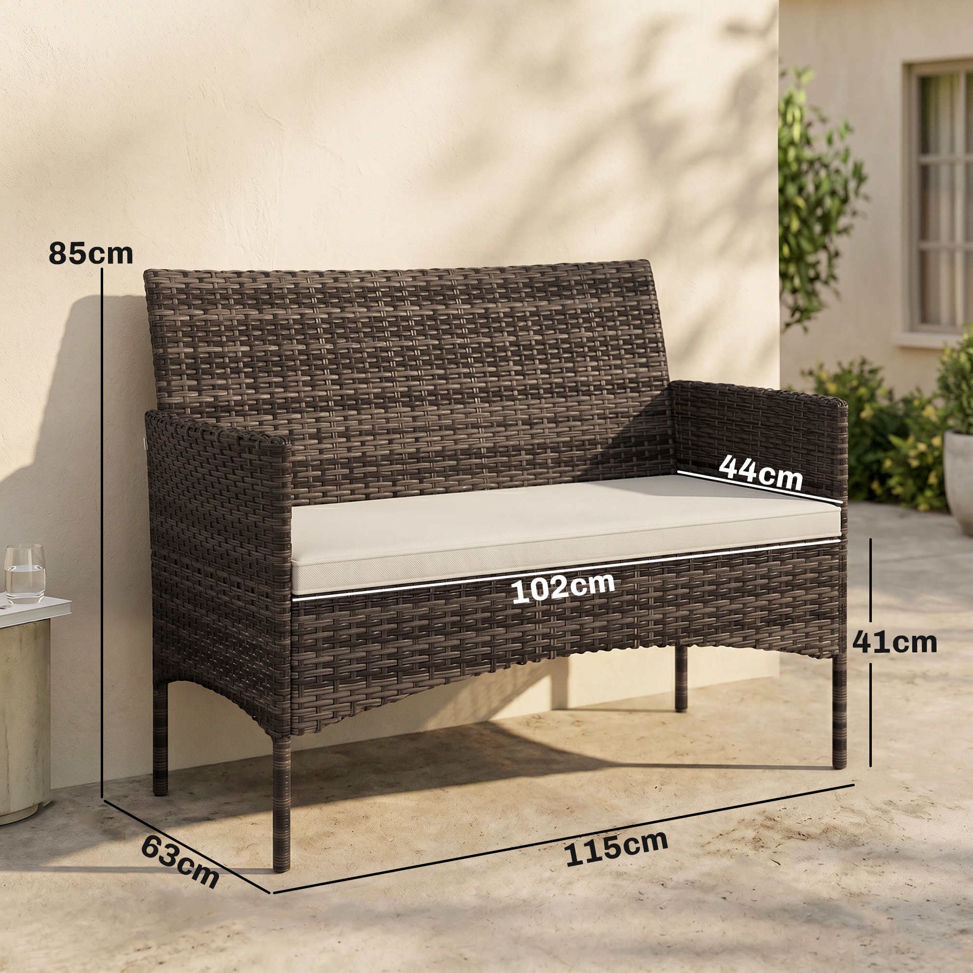 Un divano in rattan marrone con cuscino color crema all'esterno.