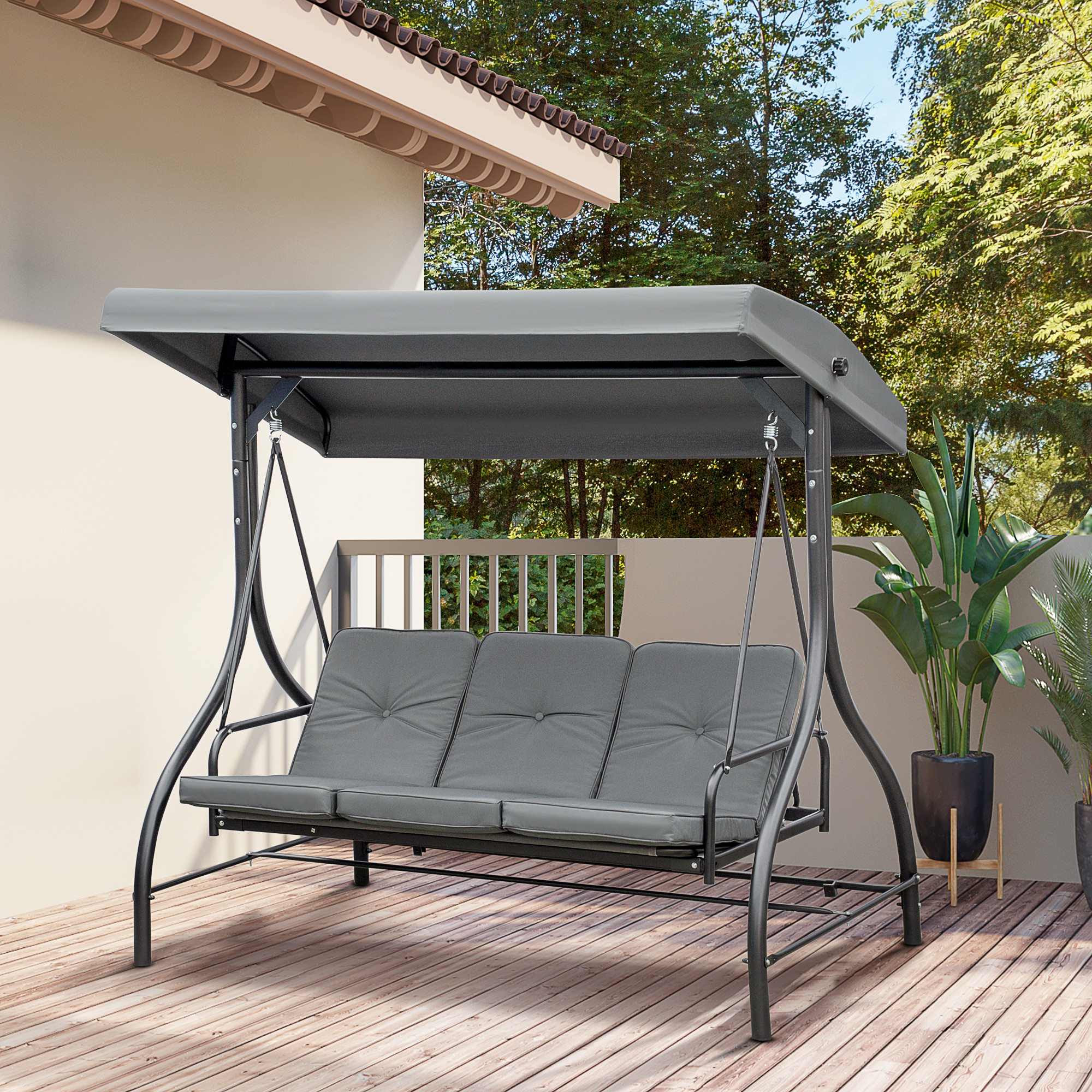 Un divano da giardino a dondolo grigio con tettoia sta su un ponte di legno.