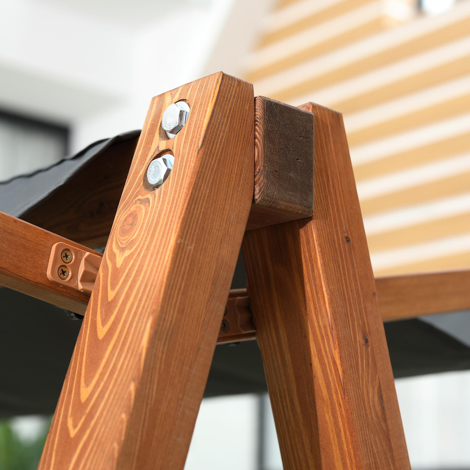 Struttura in legno con bulloni e tessuto scuro. Sfondo a strisce.