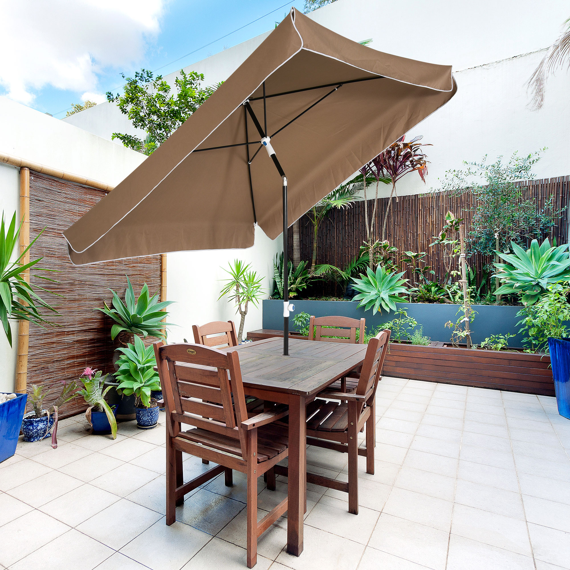 Un tavolo da giardino in legno con quattro sedie sotto un ombrellone marrone.