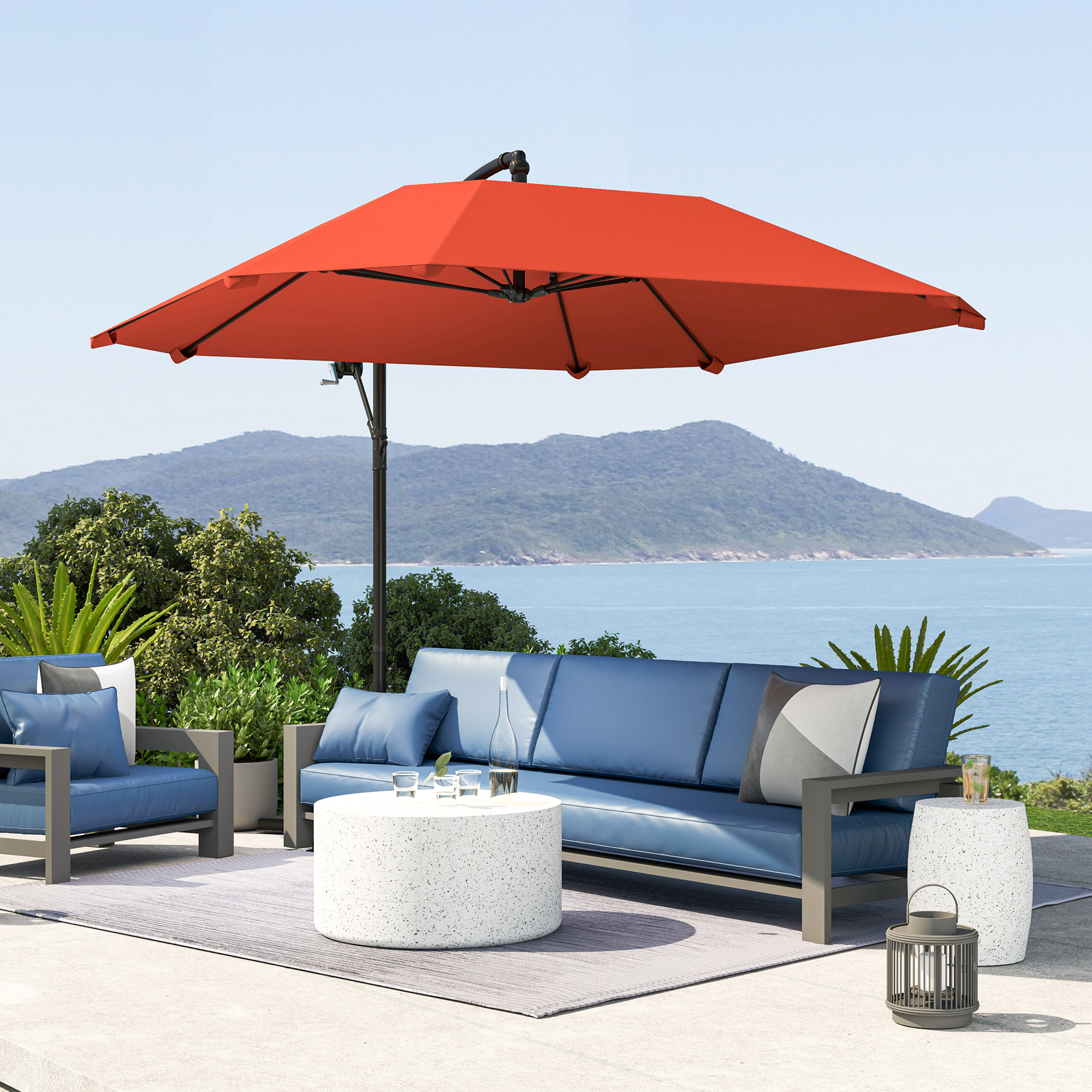 Un set da salotto da esterno blu con ombrellone arancione vicino al mare.