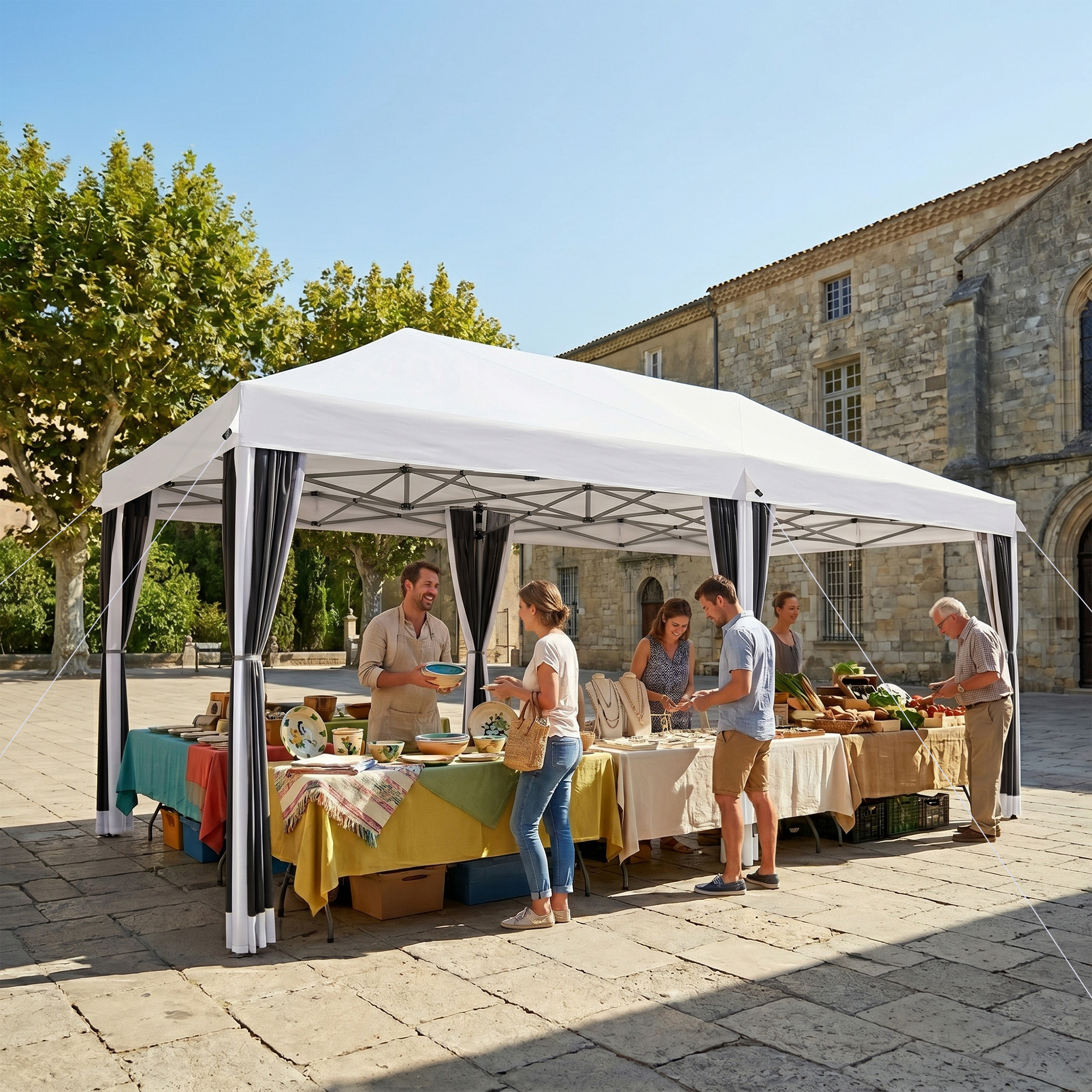 Persone fanno shopping in un mercato sotto una tenda bianca, con edifici e alberi sullo sfondo.