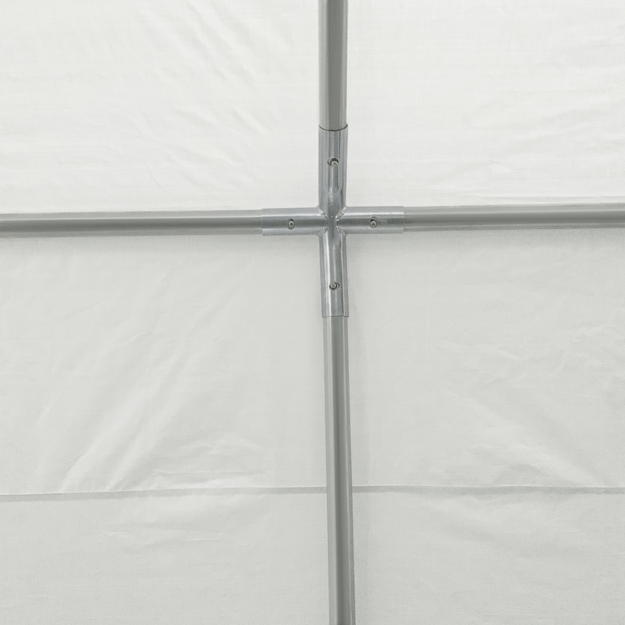Giunzione di tubi in metallo con tessuto bianco sullo sfondo.