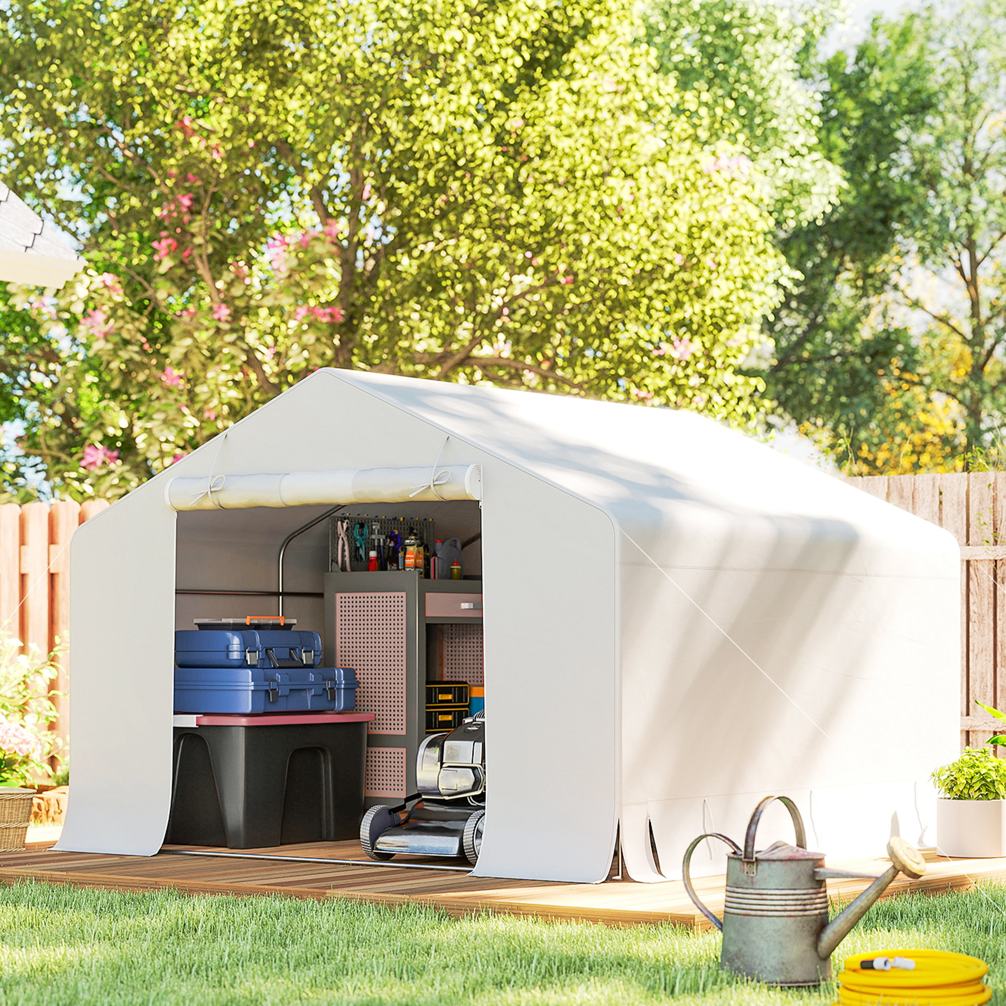 Un garage a tenda bianco con attrezzi, valigie e tosaerba. Annaffiatoio e tubo in primo piano.