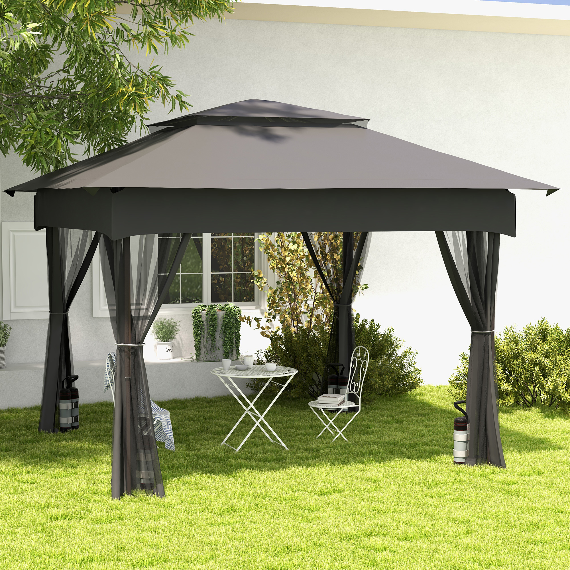 Una gazebo nera con zanzariere si trova in un giardino accanto a un tavolo e sedie.