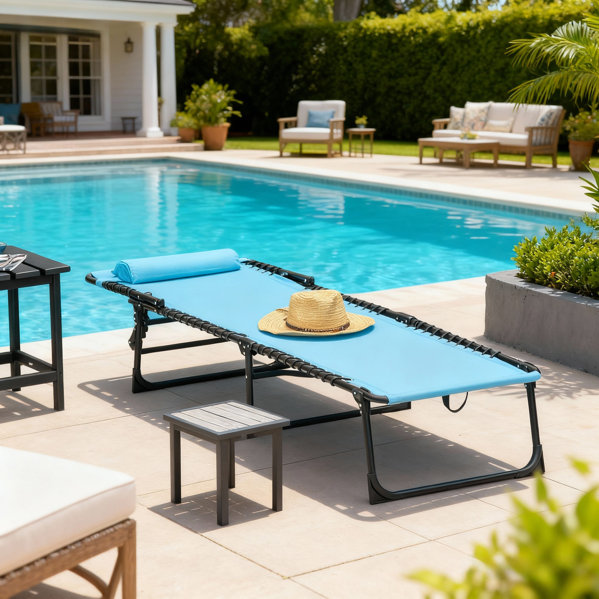 Una sdraio blu con cappello di paglia è accanto a una piscina con sedie e divano.