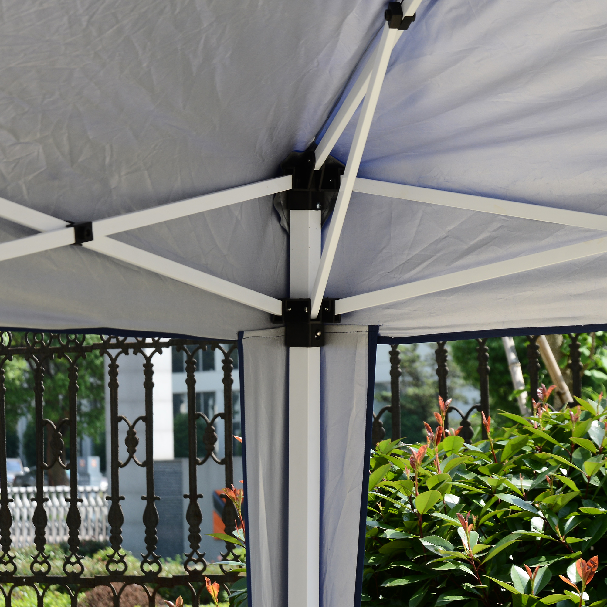 Una tenda grigia con telaio in metallo bianco e bordo blu.