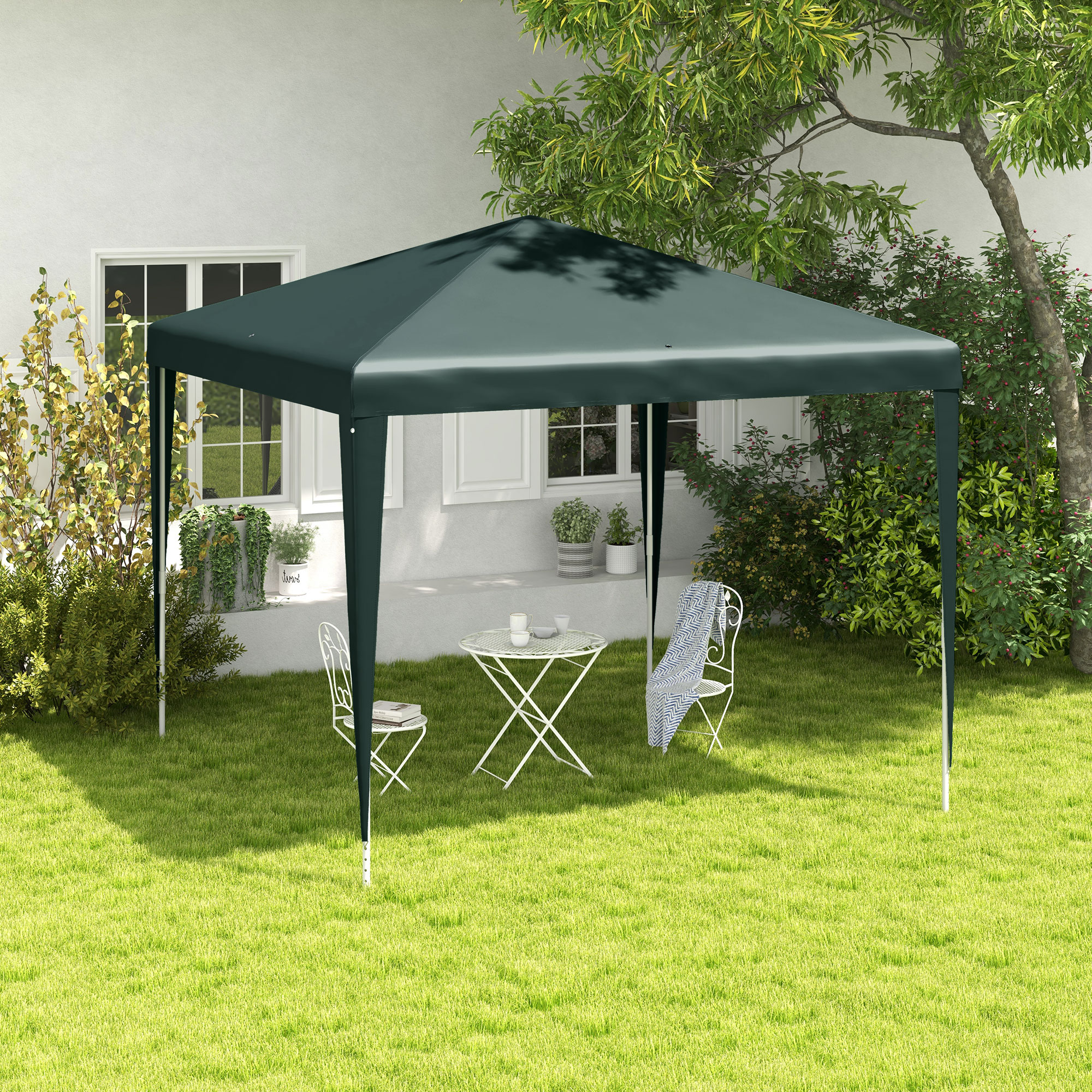 Gazebo verde scuro con tavolo e sedie bianche in giardino.