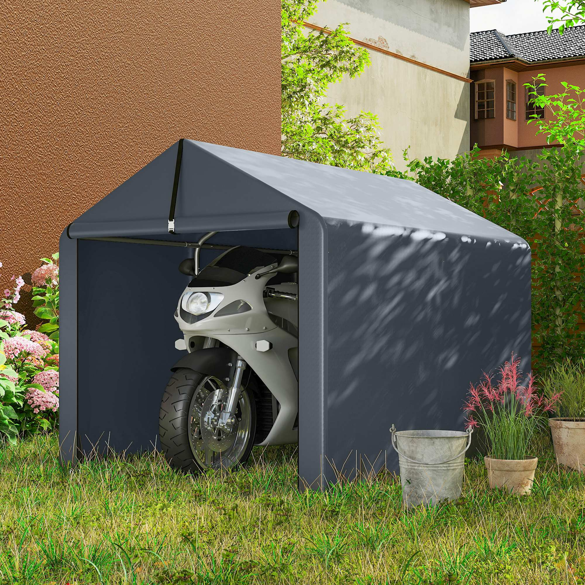 Una moto è parcheggiata in una tenda grigia sull'erba accanto a una casa.
