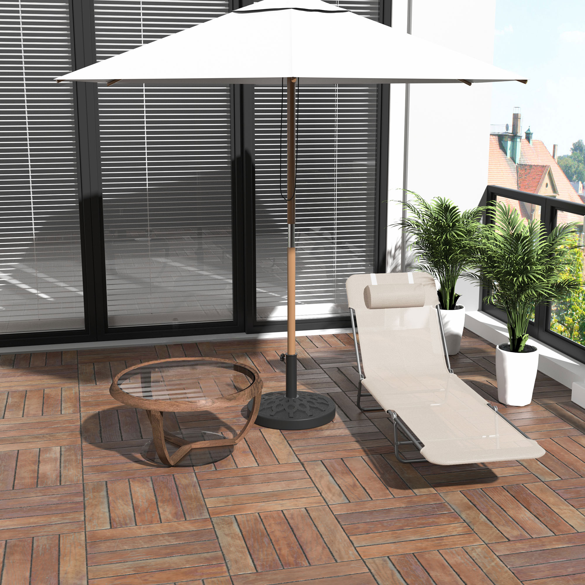 Balcone con lettino, ombrellone, tavolo e piante. Vista sulla città sullo sfondo.
