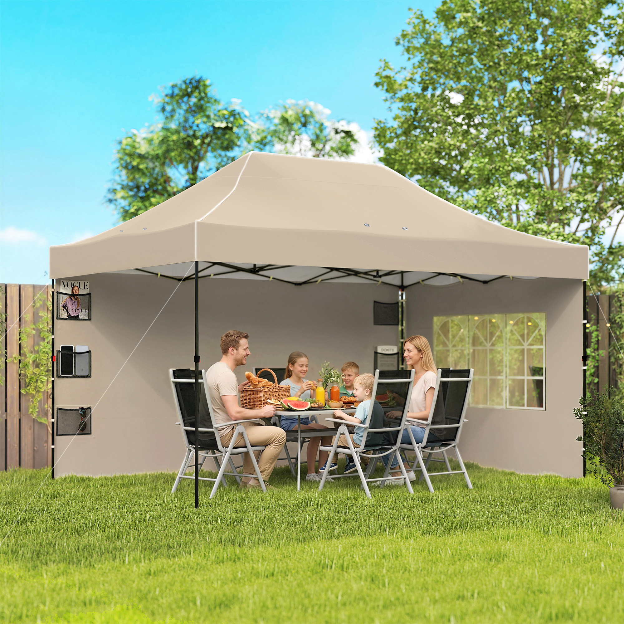 Famiglia mangia sotto una tettoia da giardino, con un cesto da picnic e cibo sul tavolo.
