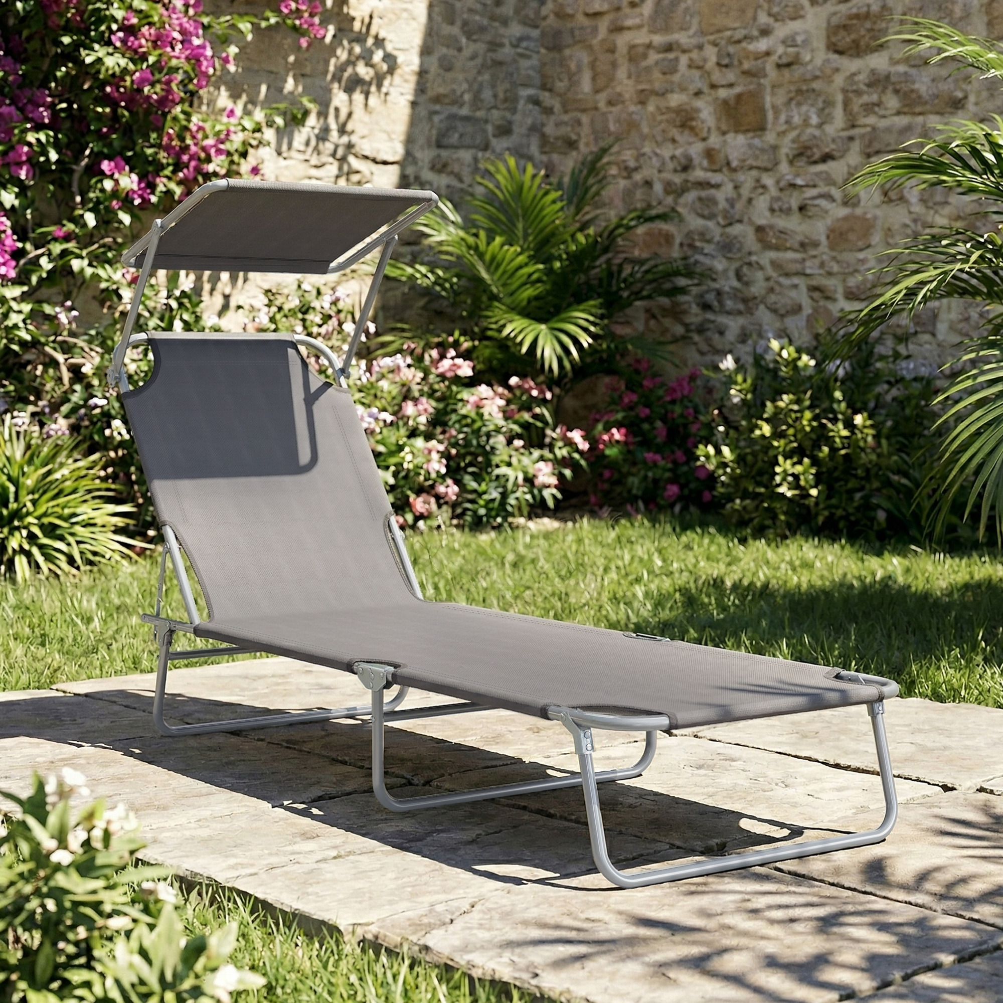 Sdraio grigio con baldacchino su lastre di pietra in un giardino.