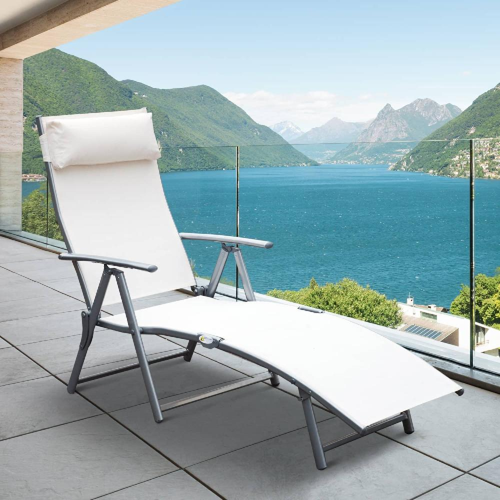 Una sdraio bianca su un balcone con vista su un lago e montagne.