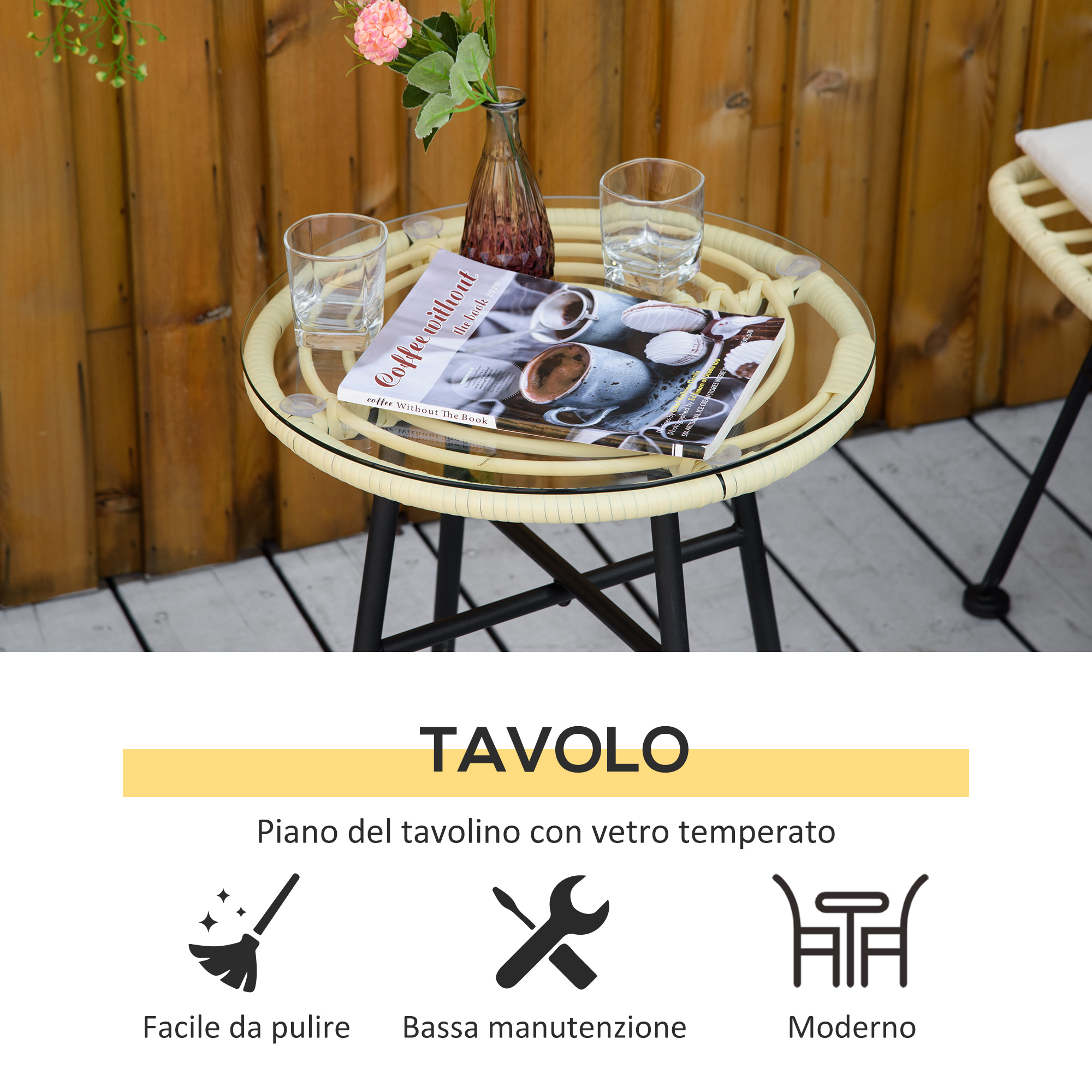 Un tavolo rotondo con piano in vetro, due bicchieri, un vaso e un libro.