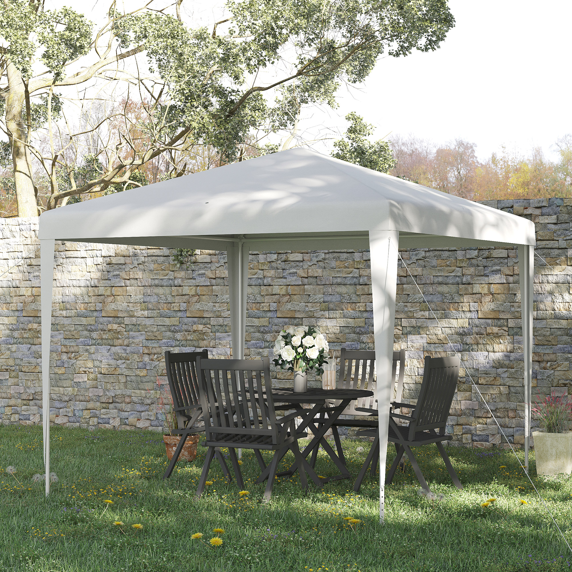 Gazebo da giardino con tavolo e sedie, fiori e muro di pietra sullo sfondo.