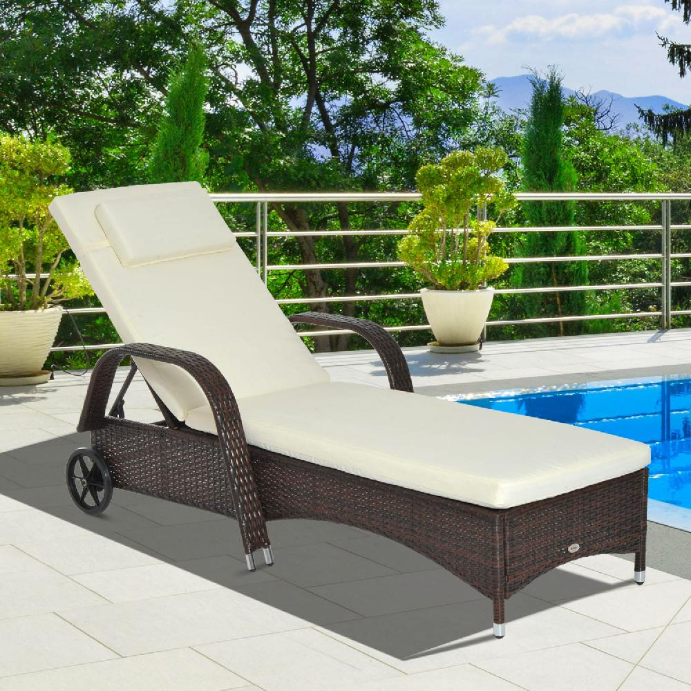 Lettino prendisole in rattan marrone scuro con cuscino color crema vicino piscina blu.
