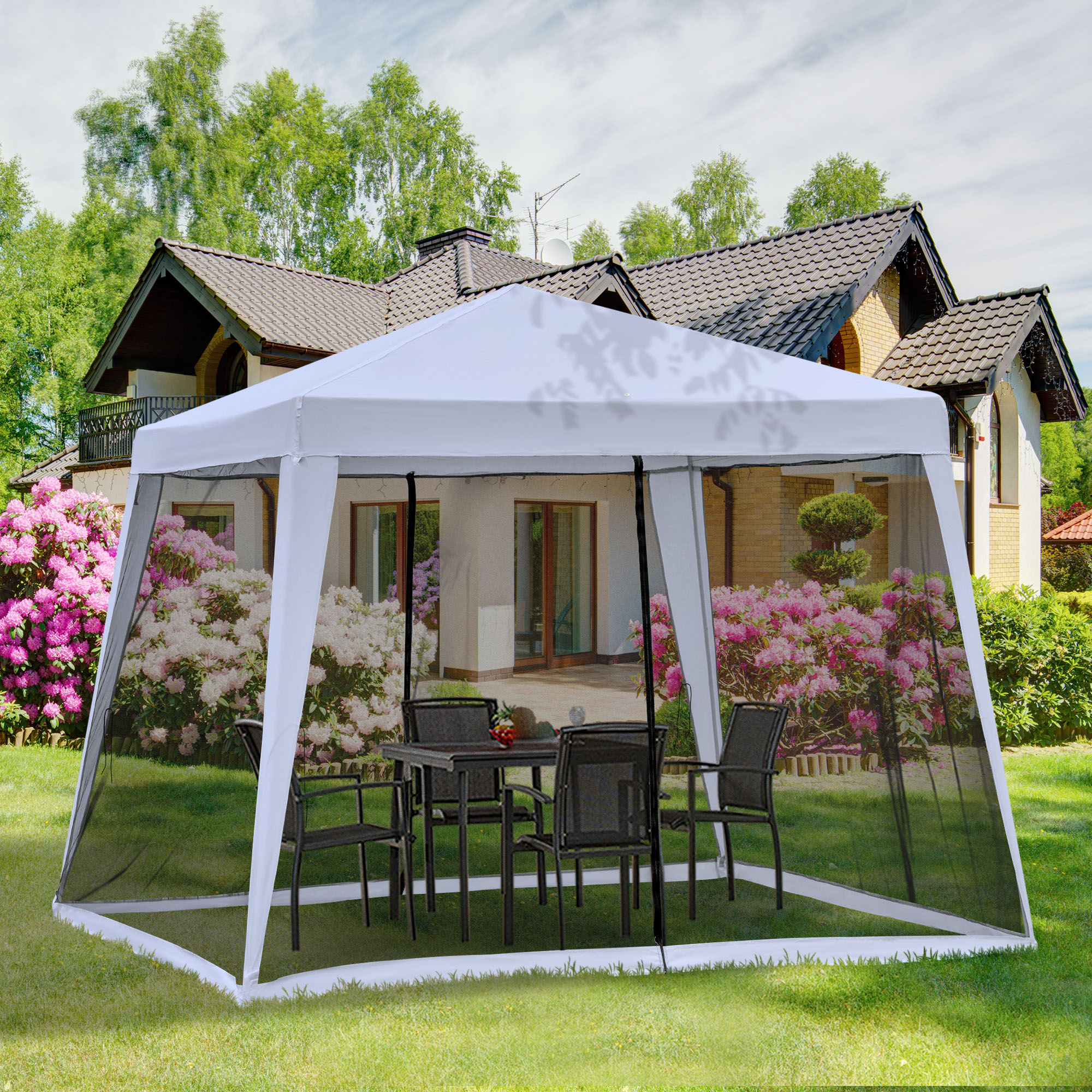 Un gazebo bianco con tavolo e sedie è in un giardino di fronte a una casa.