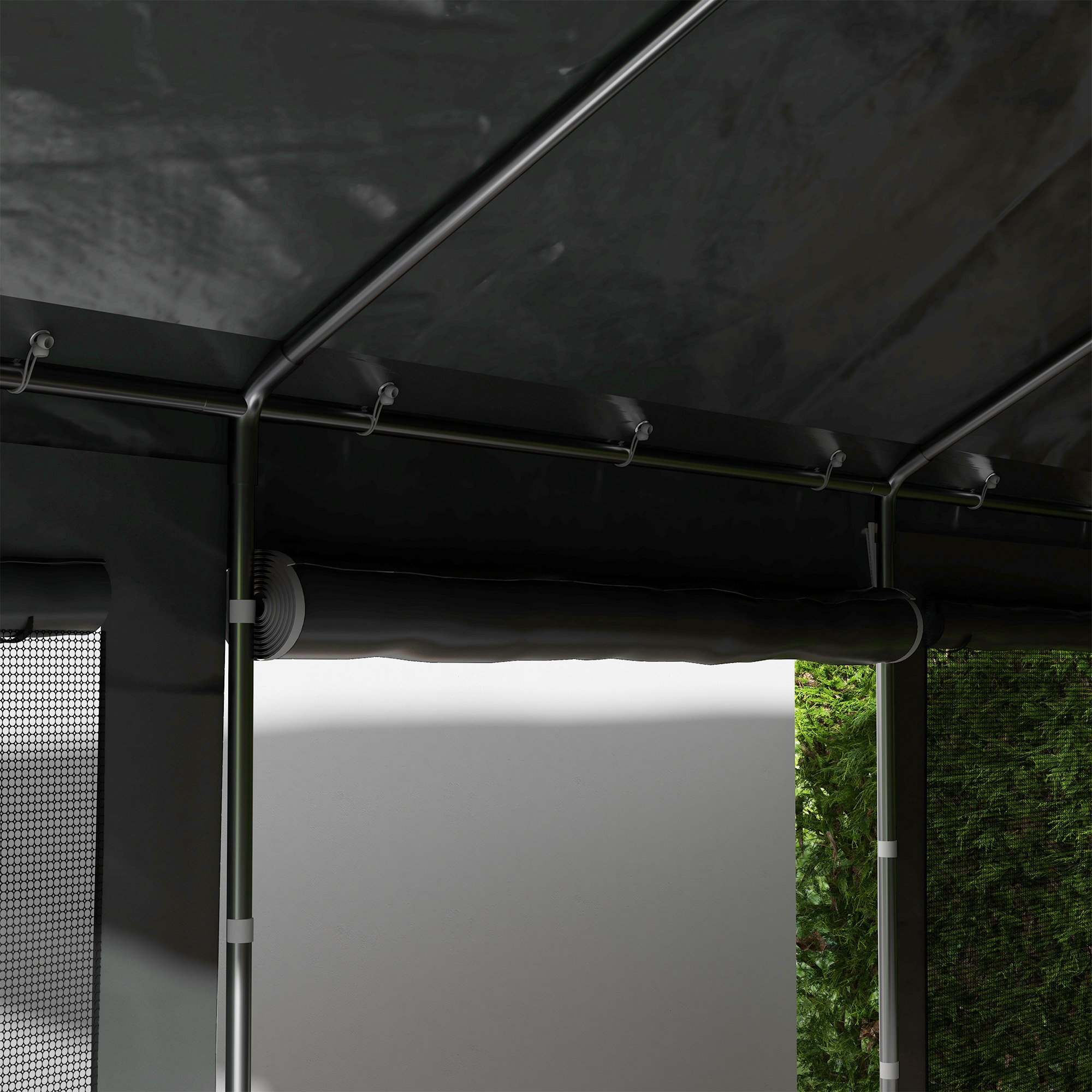 Primo piano di una tenda nera con pali metallici e tapparelle laterali avvolgibili. Vegetazione visibile all'esterno.