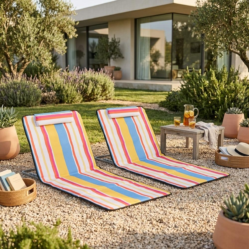 Due sdraio colorate su ghiaia davanti a una casa moderna in giardino.