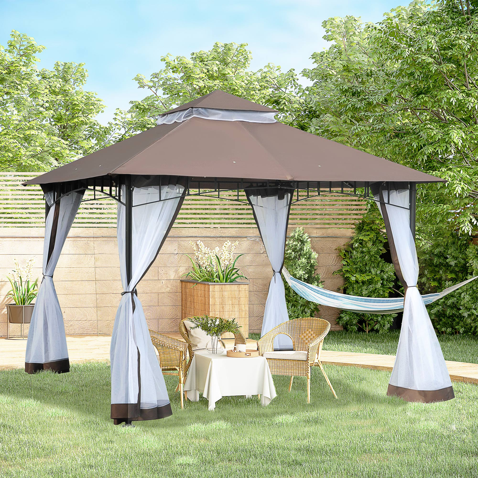 Un gazebo marrone con tende bianche si erge sull'erba, con mobili e amaca.