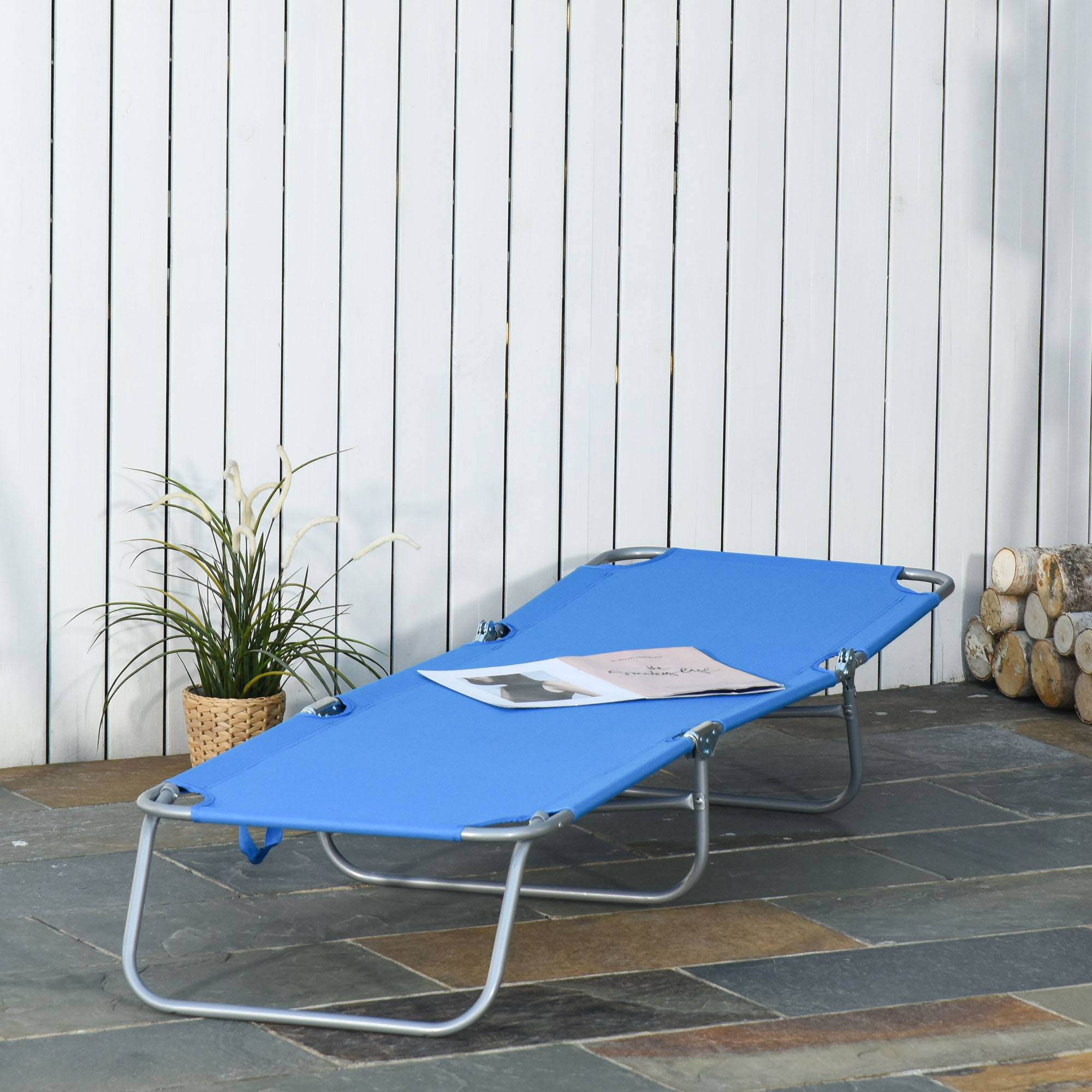 Una sdraio blu con telaio argentato poggia su un patio di lastre.