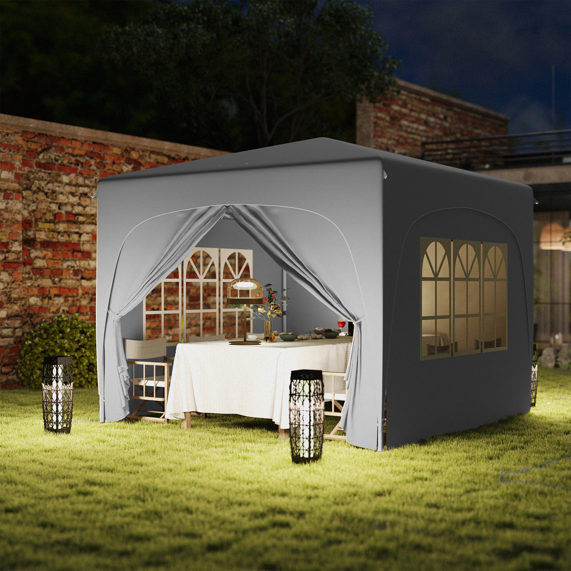 Una tenda grigia con tavolo e sedie in giardino di notte, illuminata da lanterne.