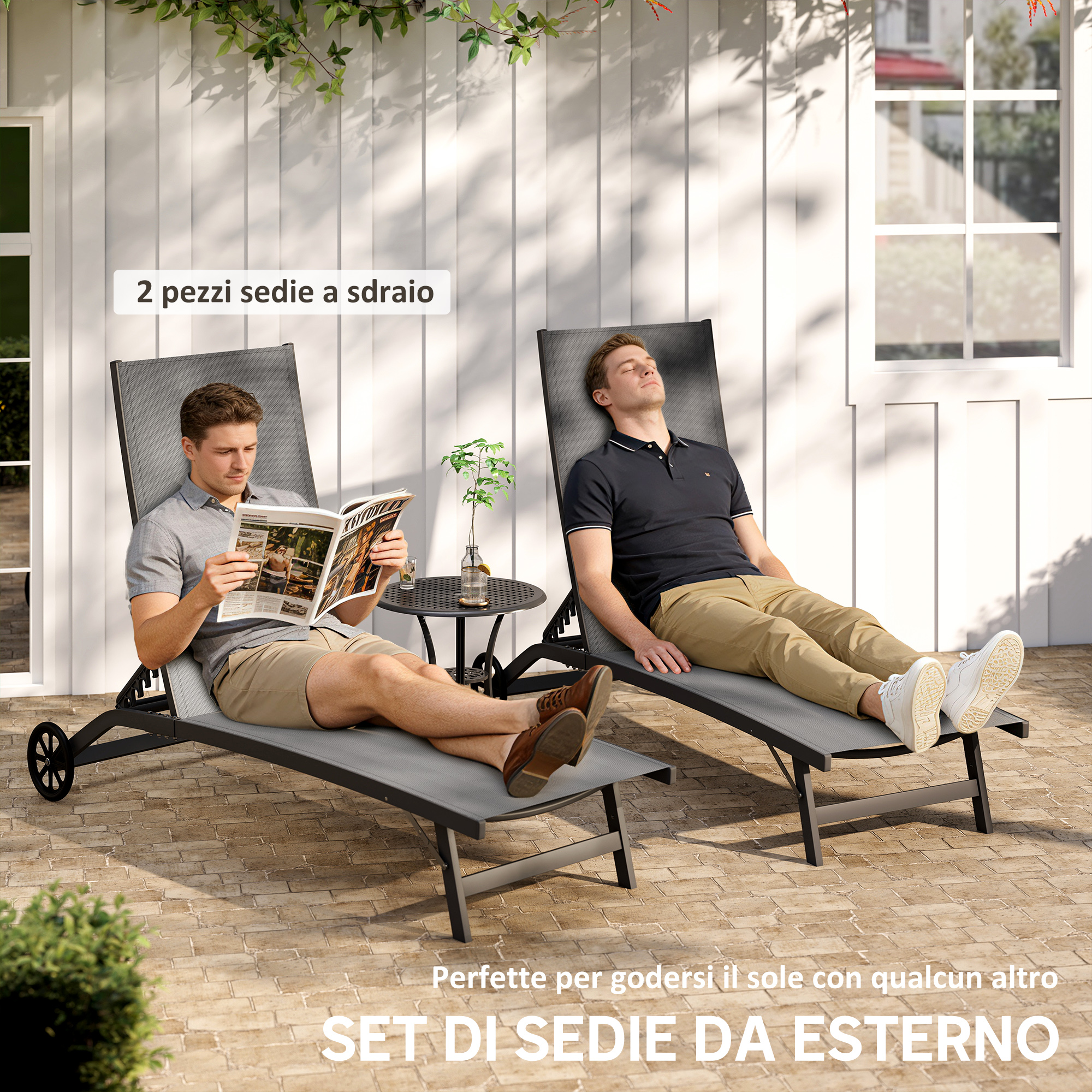 Due sedie a sdraio grigie su un patio pavimentato, un uomo legge, un altro si rilassa.