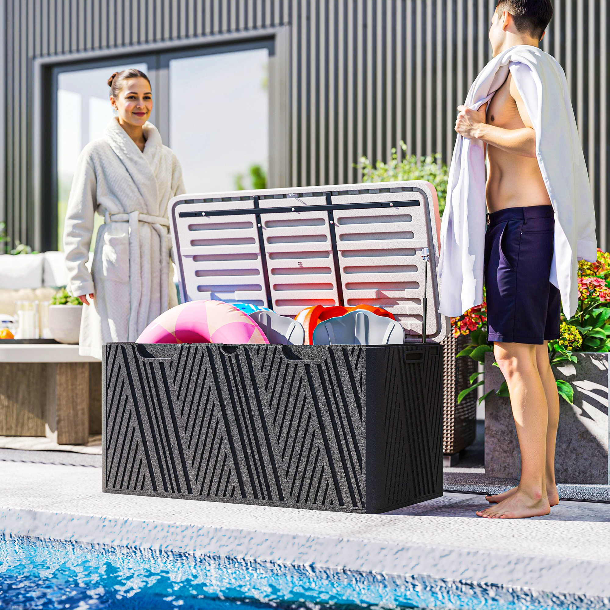 Un uomo e una donna stanno accanto a una scatola portaoggetti nera aperta piena di accessori per piscina.
