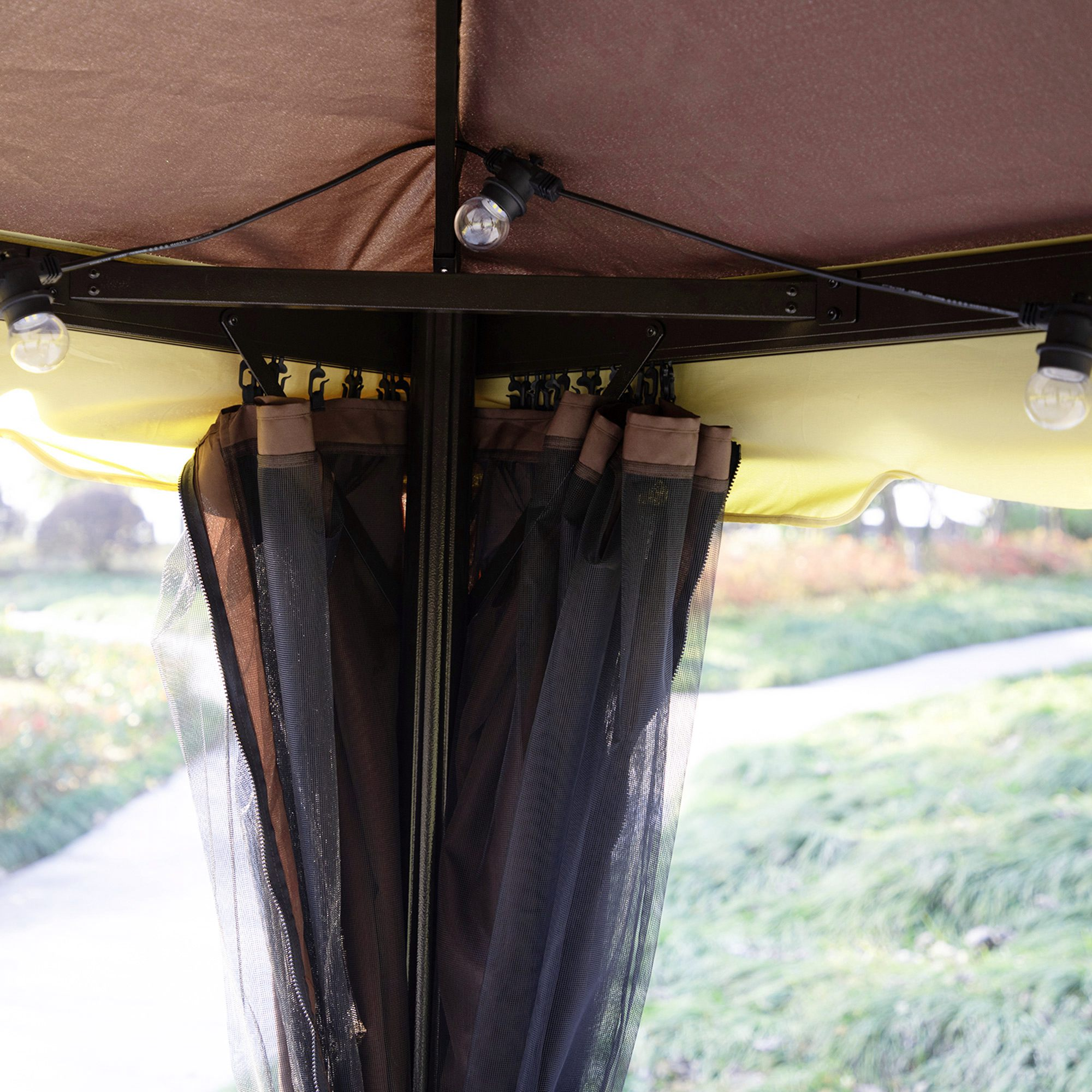Tenda marrone con tende zanzariere e lucine.