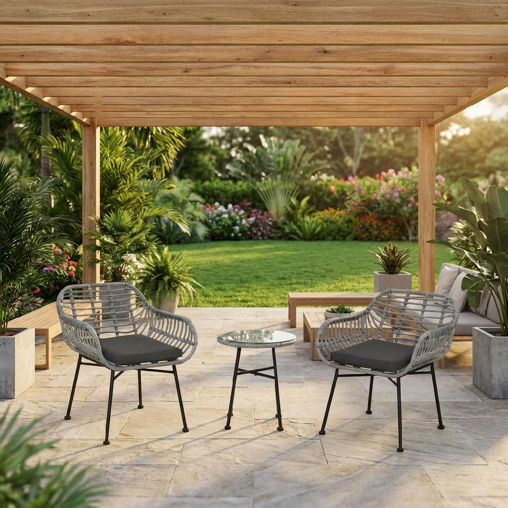 Due sedie grigie in rattan con cuscini sotto un pergolato di legno che si affaccia su un giardino.