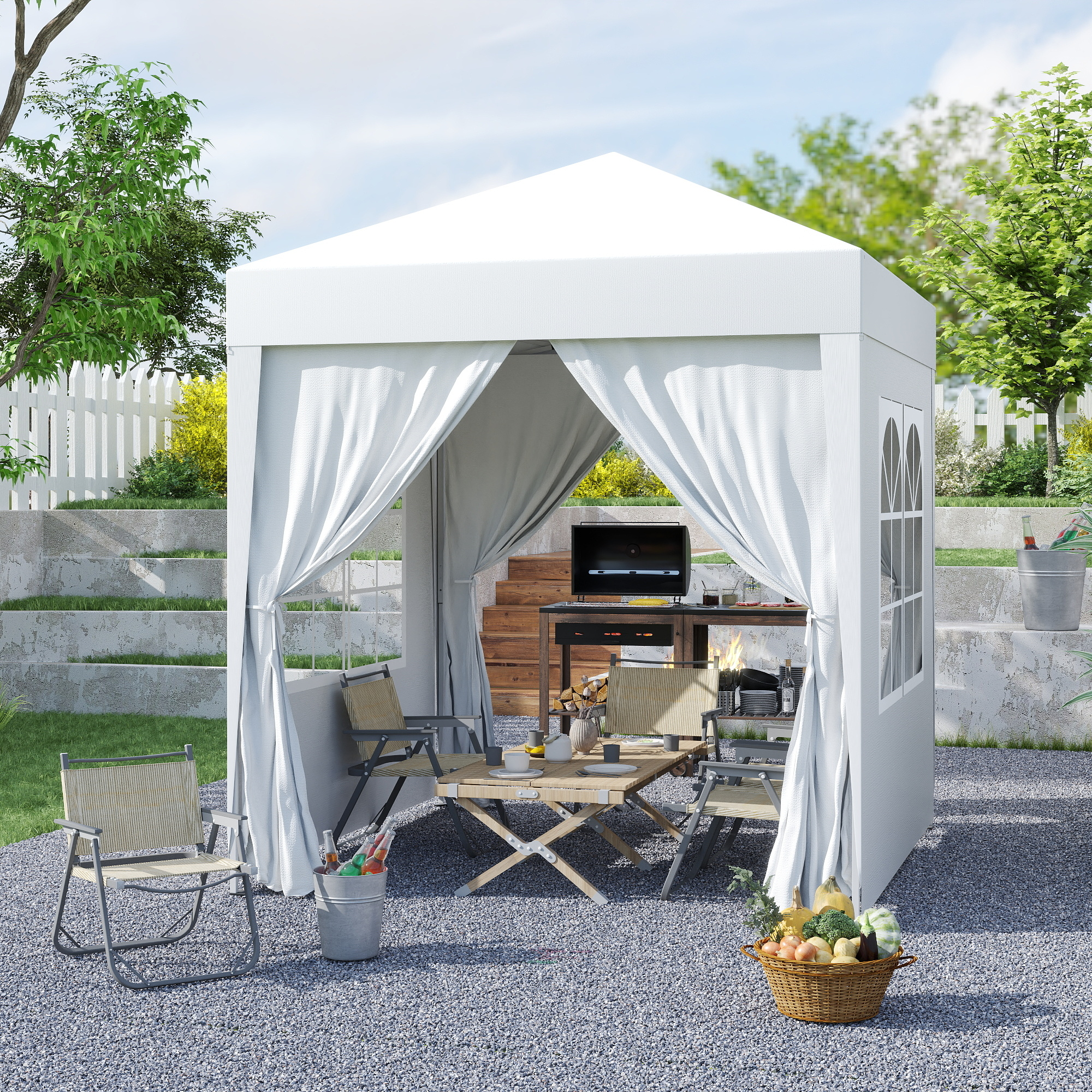 Un gazebo bianco in giardino con griglia, tavolo e sedie. Un cesto di verdure.