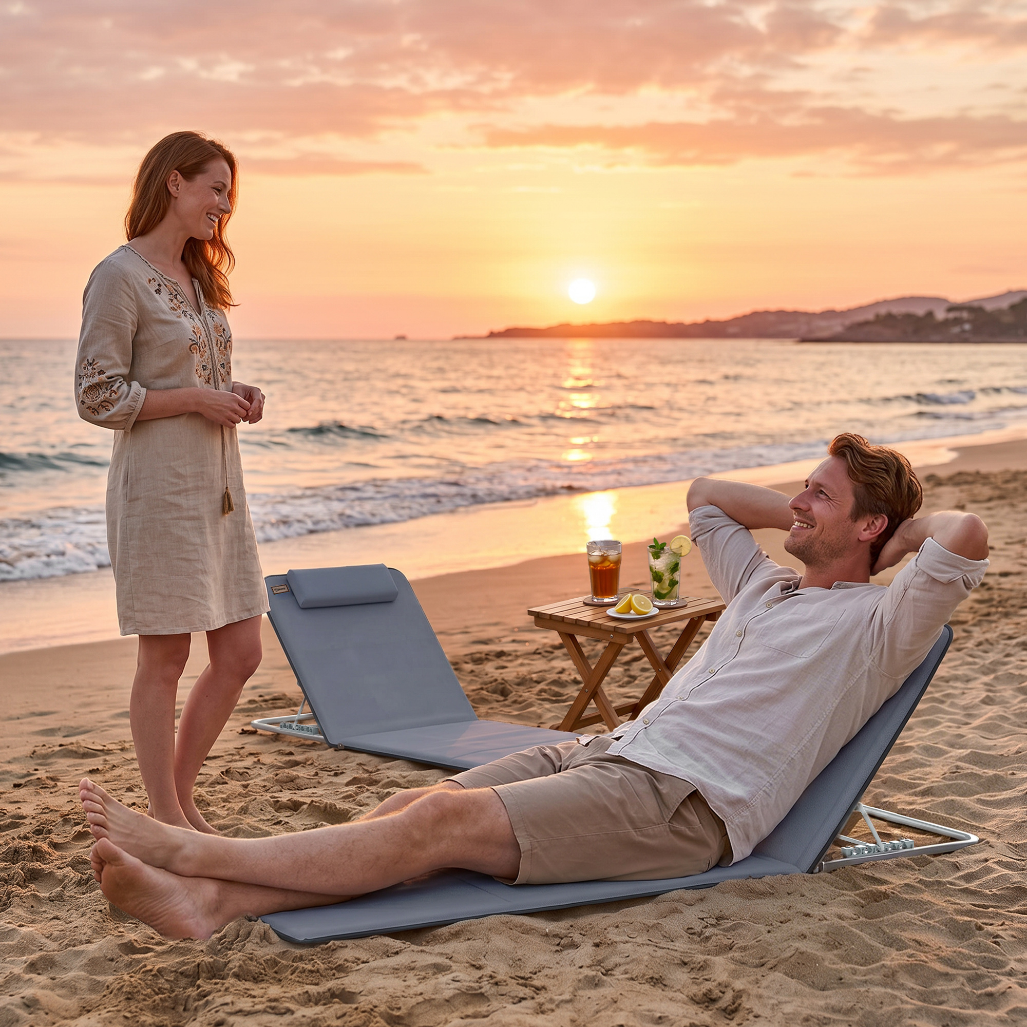 Coppia rilassante su sedie da spiaggia al tramonto con bevande.
