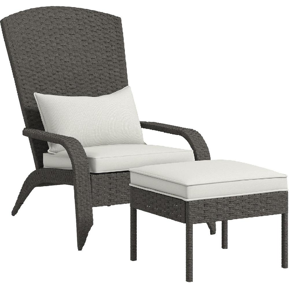 Una sedia in rattan grigio con cuscino bianco e pouf.