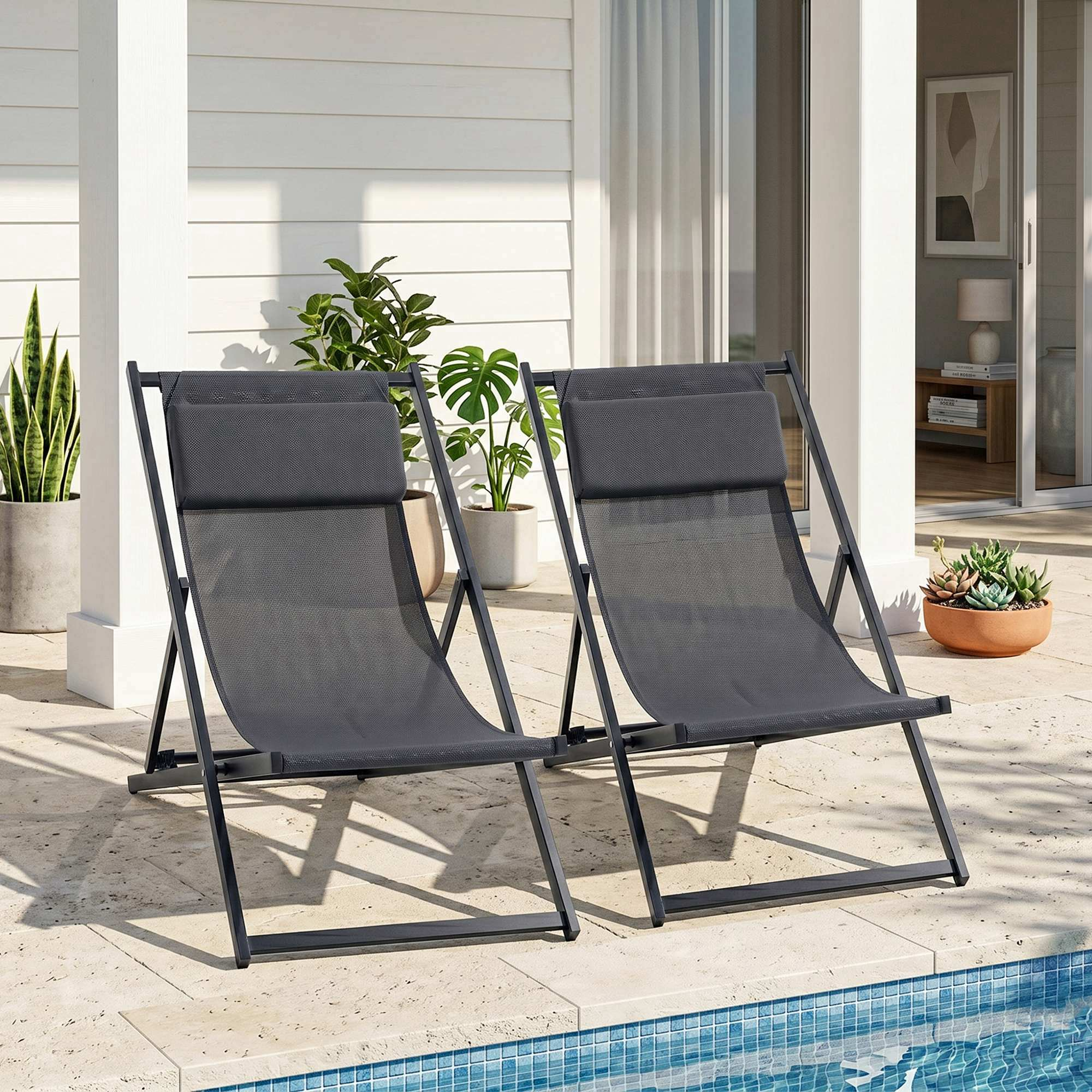 Due sedie a sdraio scure su un patio vicino a una piscina.