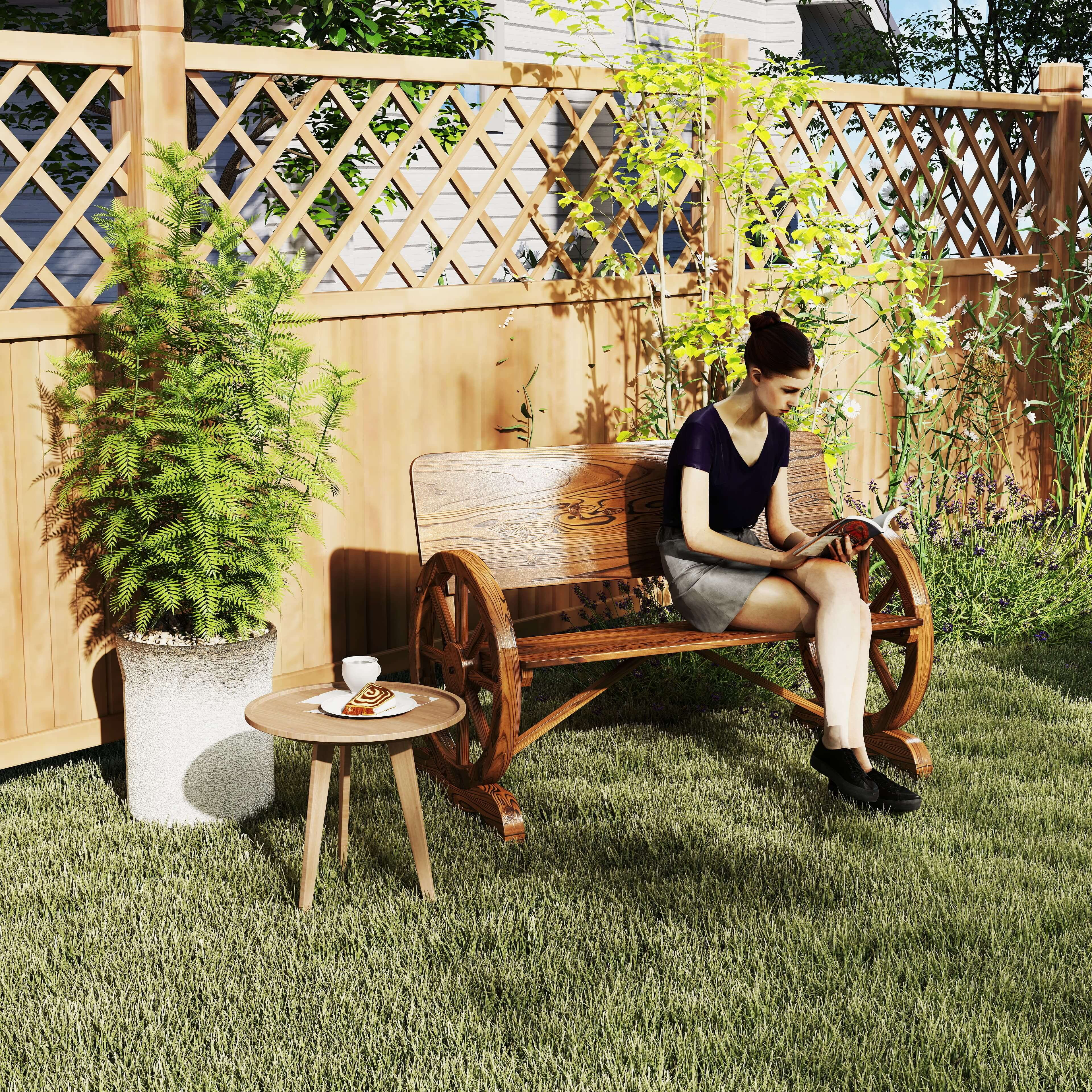 Una donna legge un libro su una panchina di legno in un giardino con fiori.