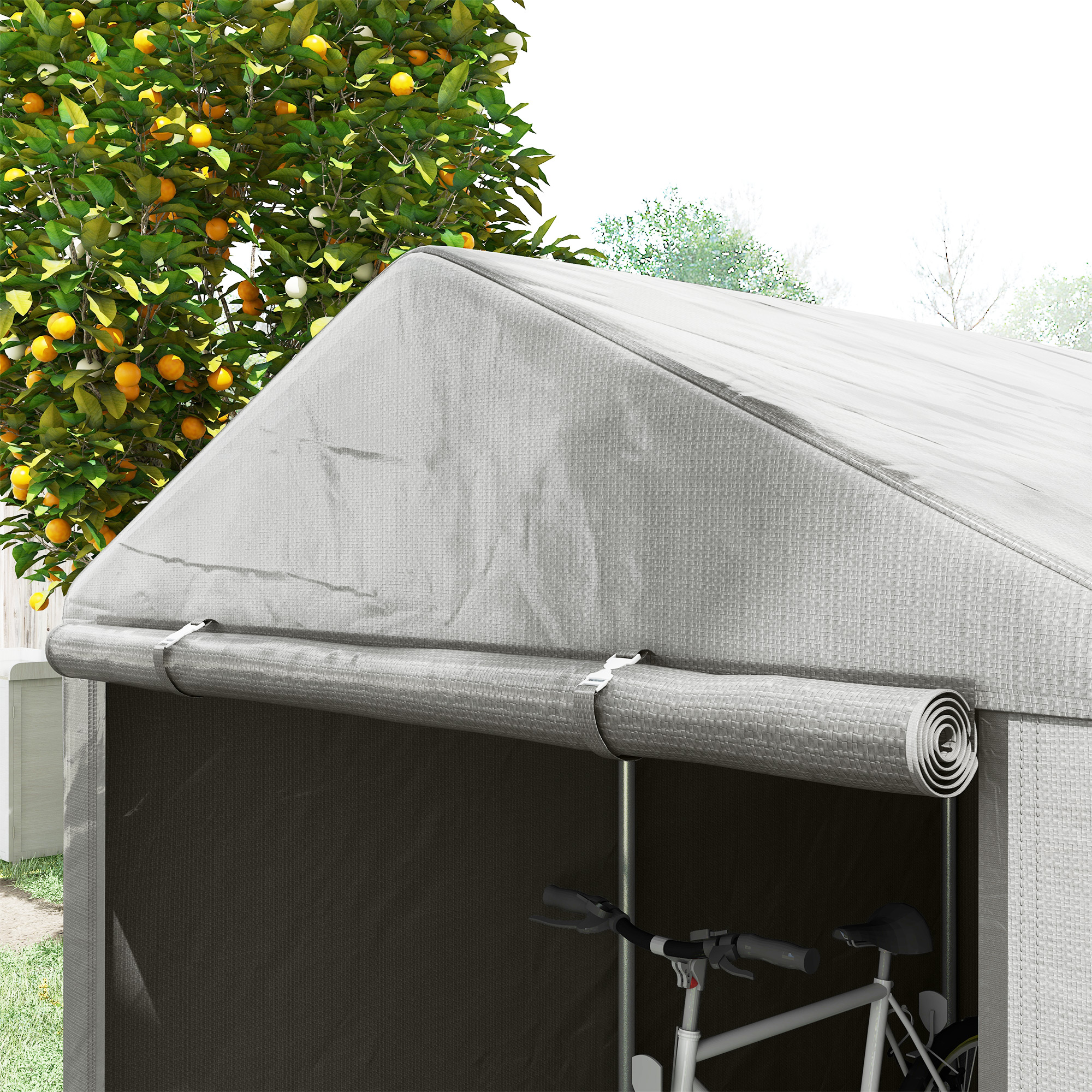 Una tenda grigia con porta arrotolata, accanto a un albero di arance.