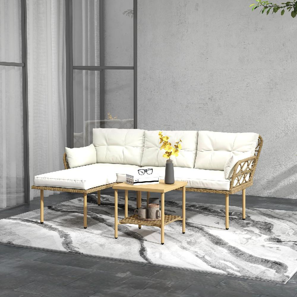 Un divano in rattan beige con cuscini bianchi e un tavolino di legno.