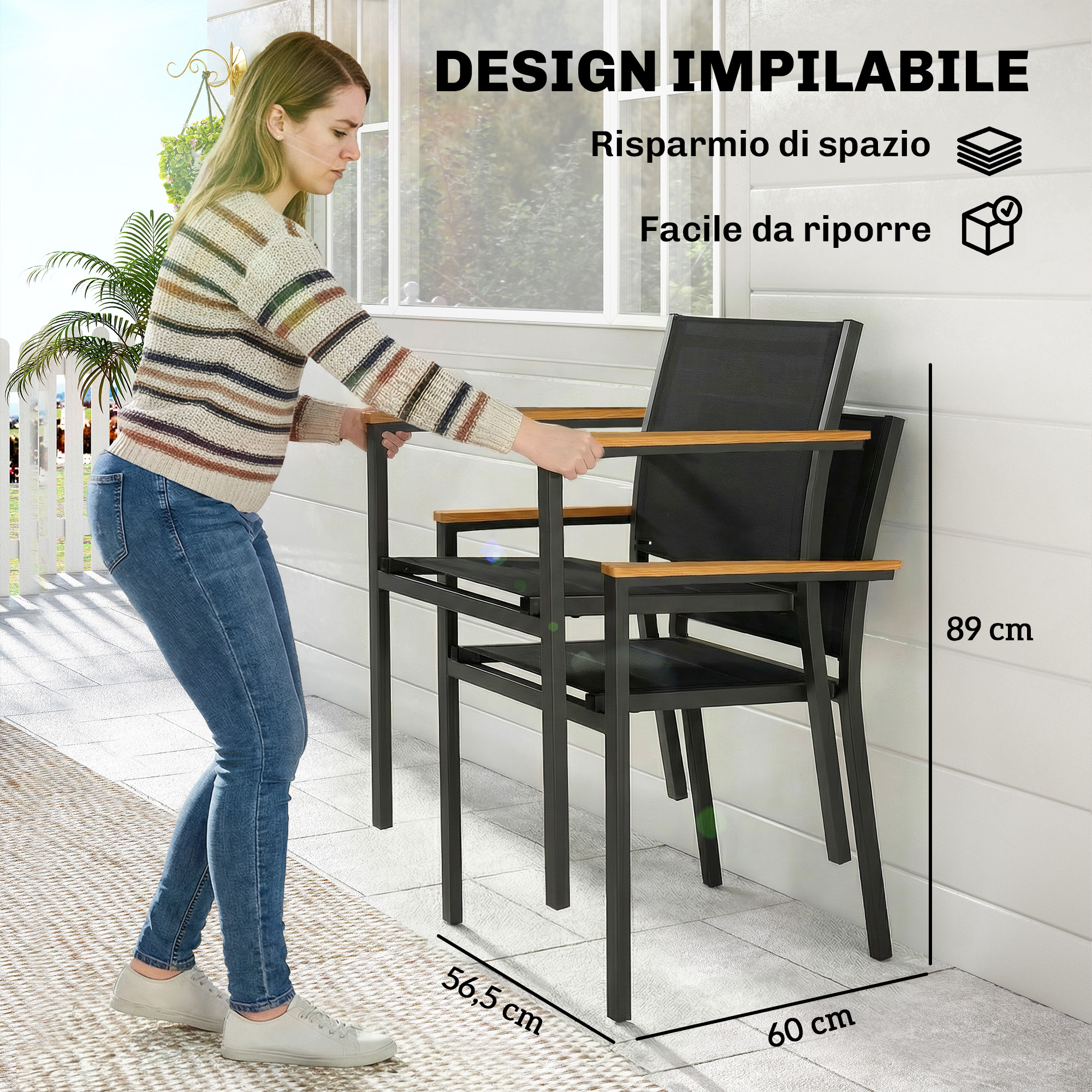 Una donna impila sedie nere con braccioli in legno su un patio.
