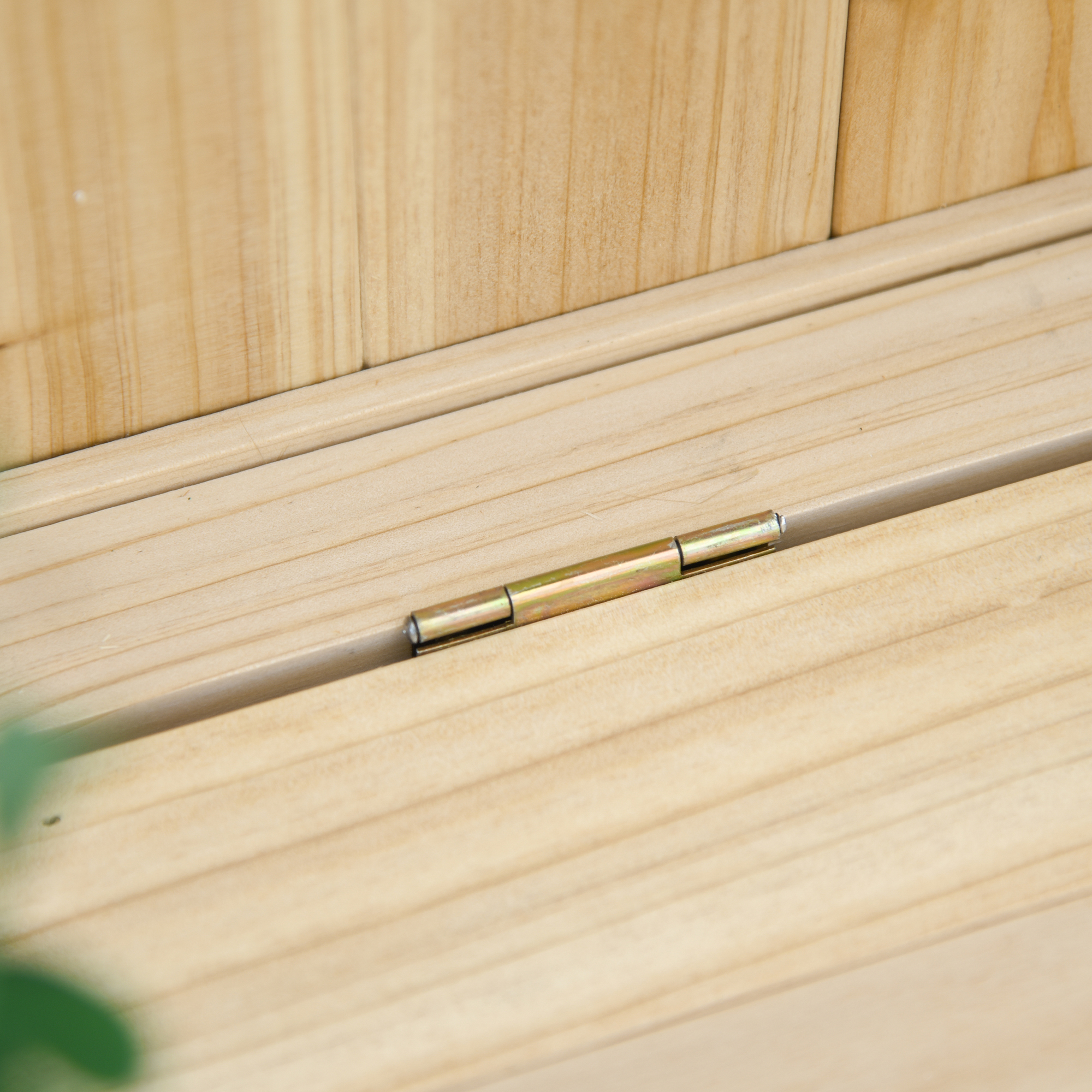Una cerniera dorata su legno marrone chiaro.