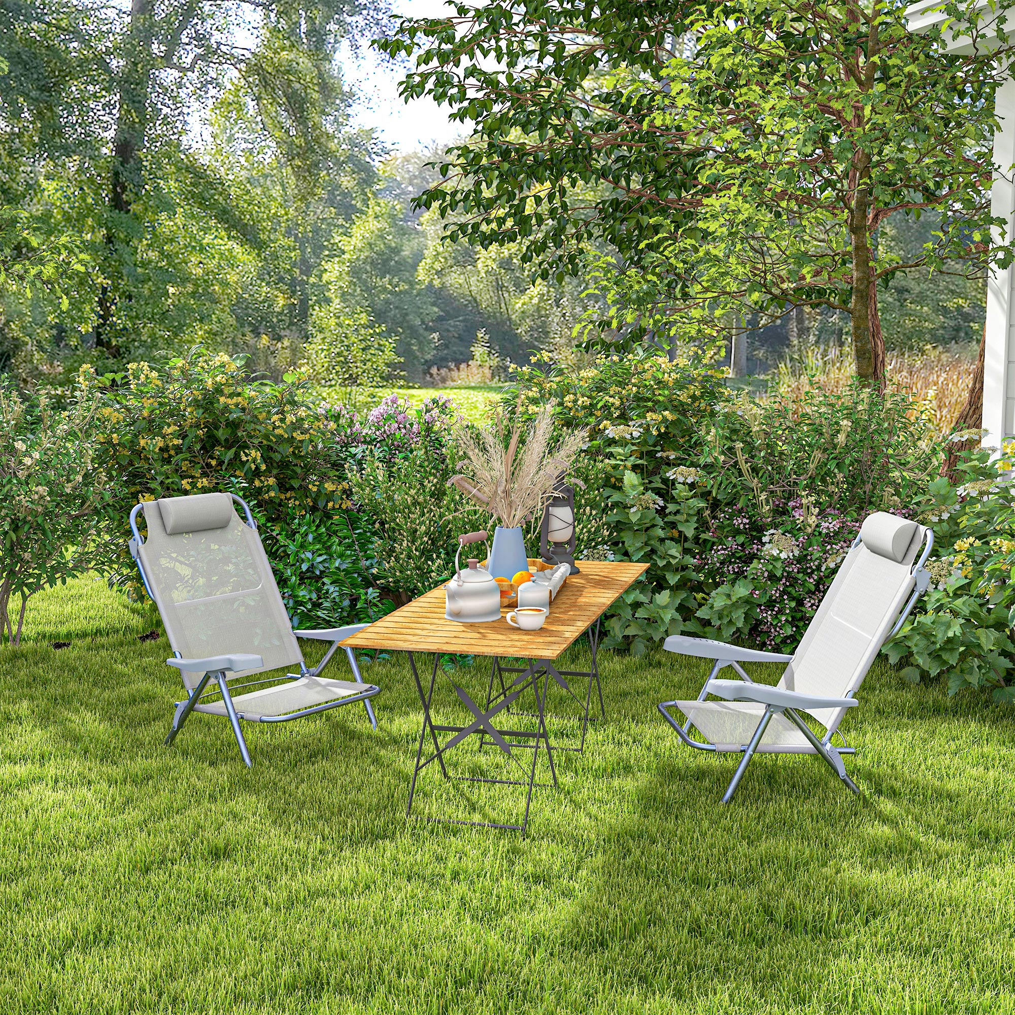 Arredo da giardino nel verde con tavolo e due sdraio.