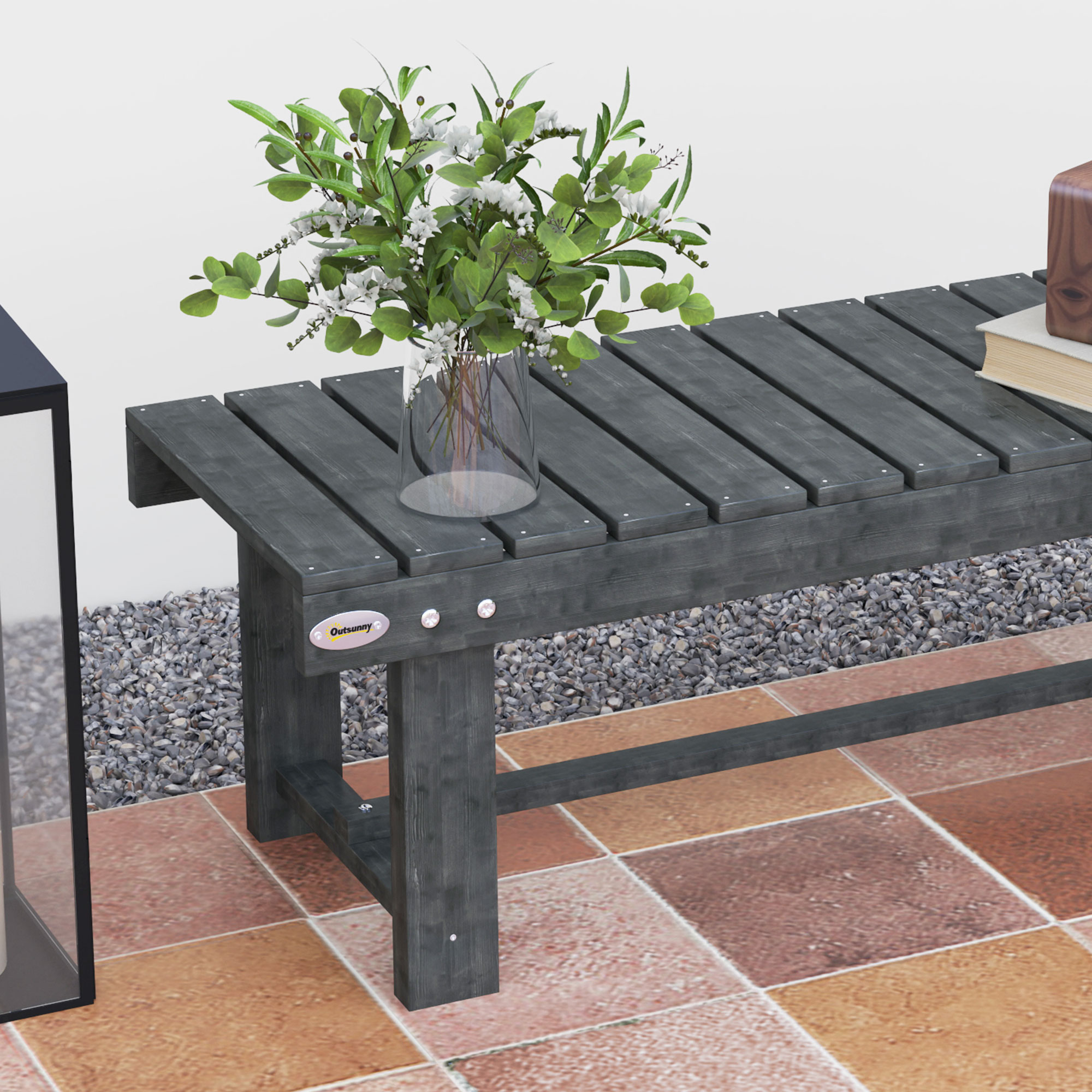 Una panchina in legno scuro con fiori e libri su un pavimento piastrellato.