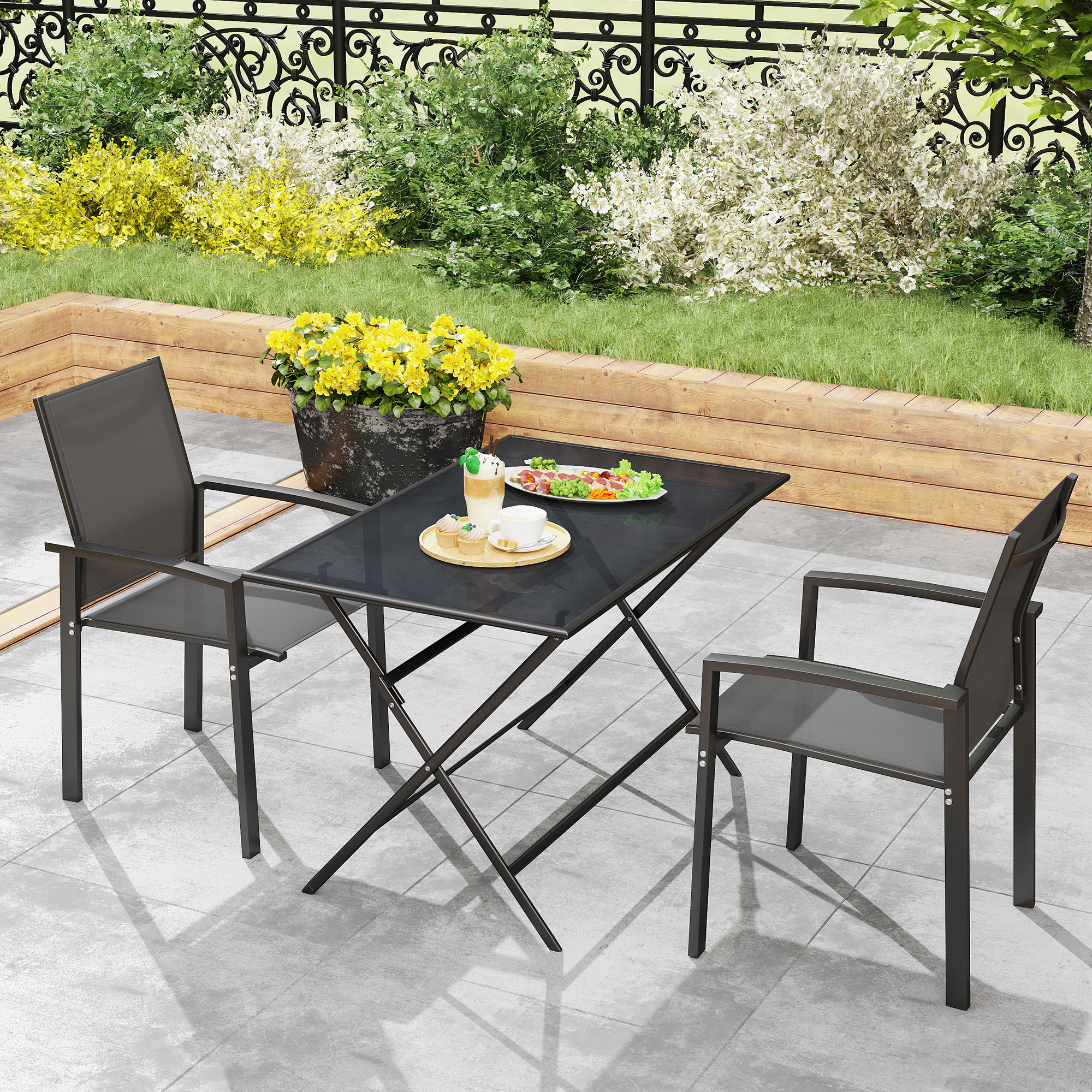 Un set da esterno in metallo nero con tavolo e due sedie su un patio con cibo e bevande.