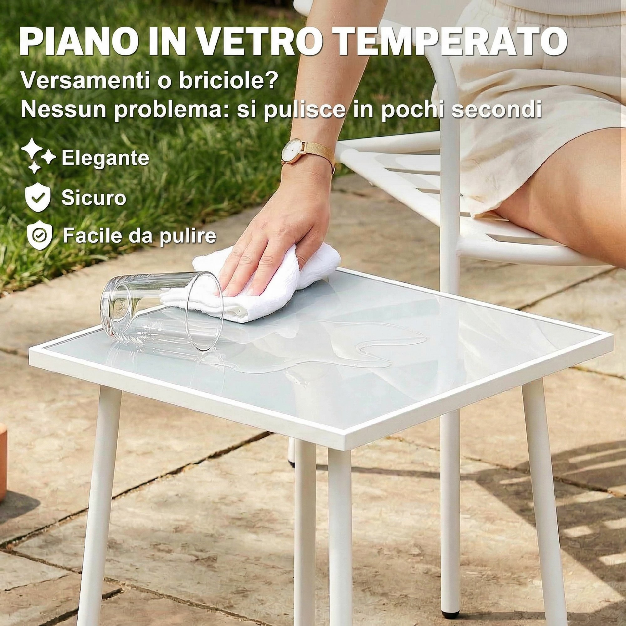 Una mano pulisce un tavolo in vetro all'aperto con un panno bianco.