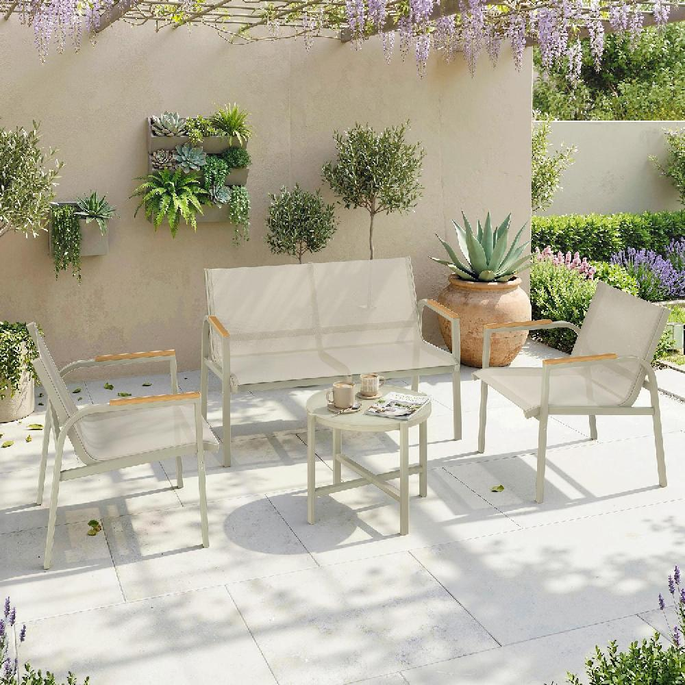 Patio esterno con mobili grigio chiaro: divano, due sedie e tavolino. Piante e glicine adornano la scena.