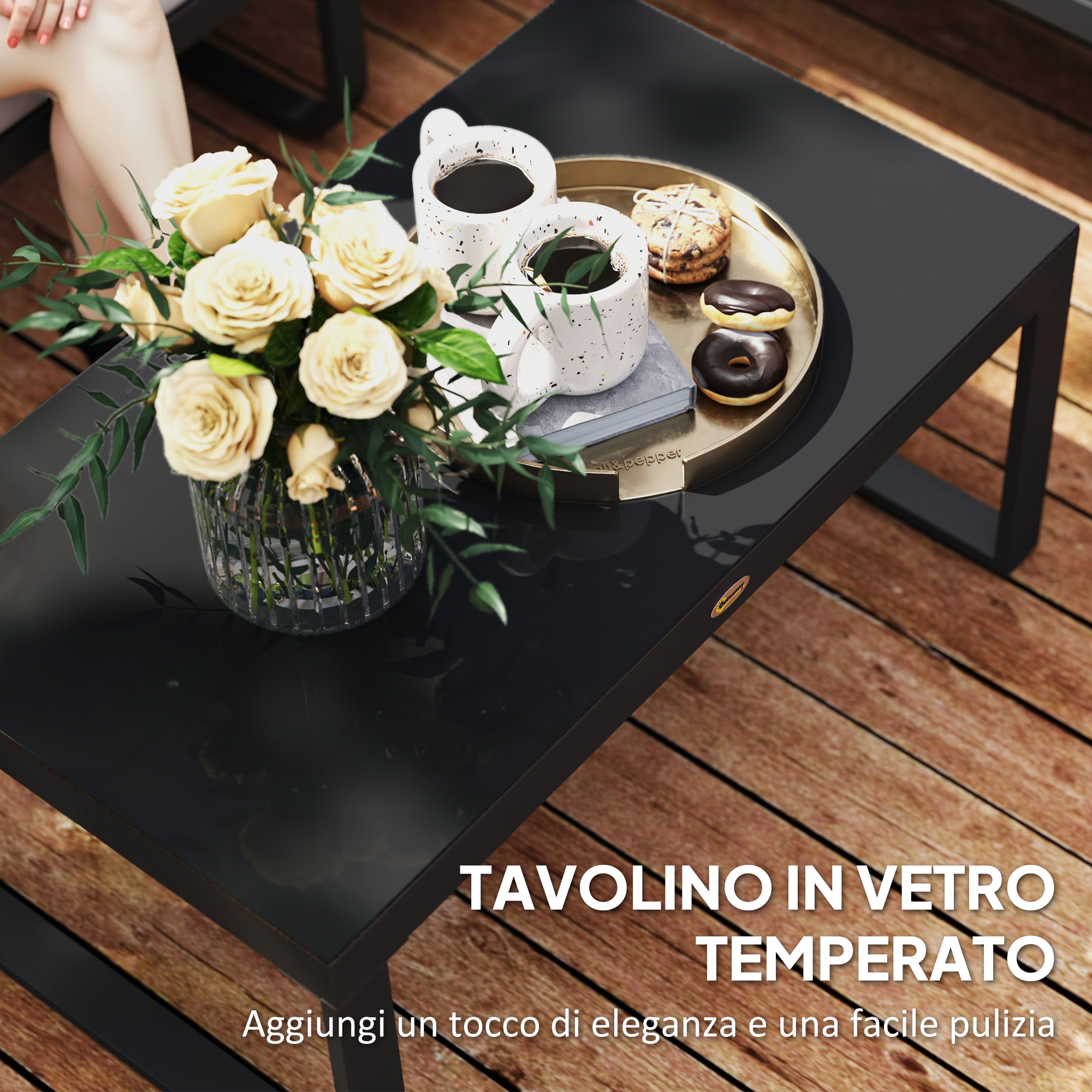 Tavolino nero in vetro con rose, caffè e ciambelle su un deck di legno.