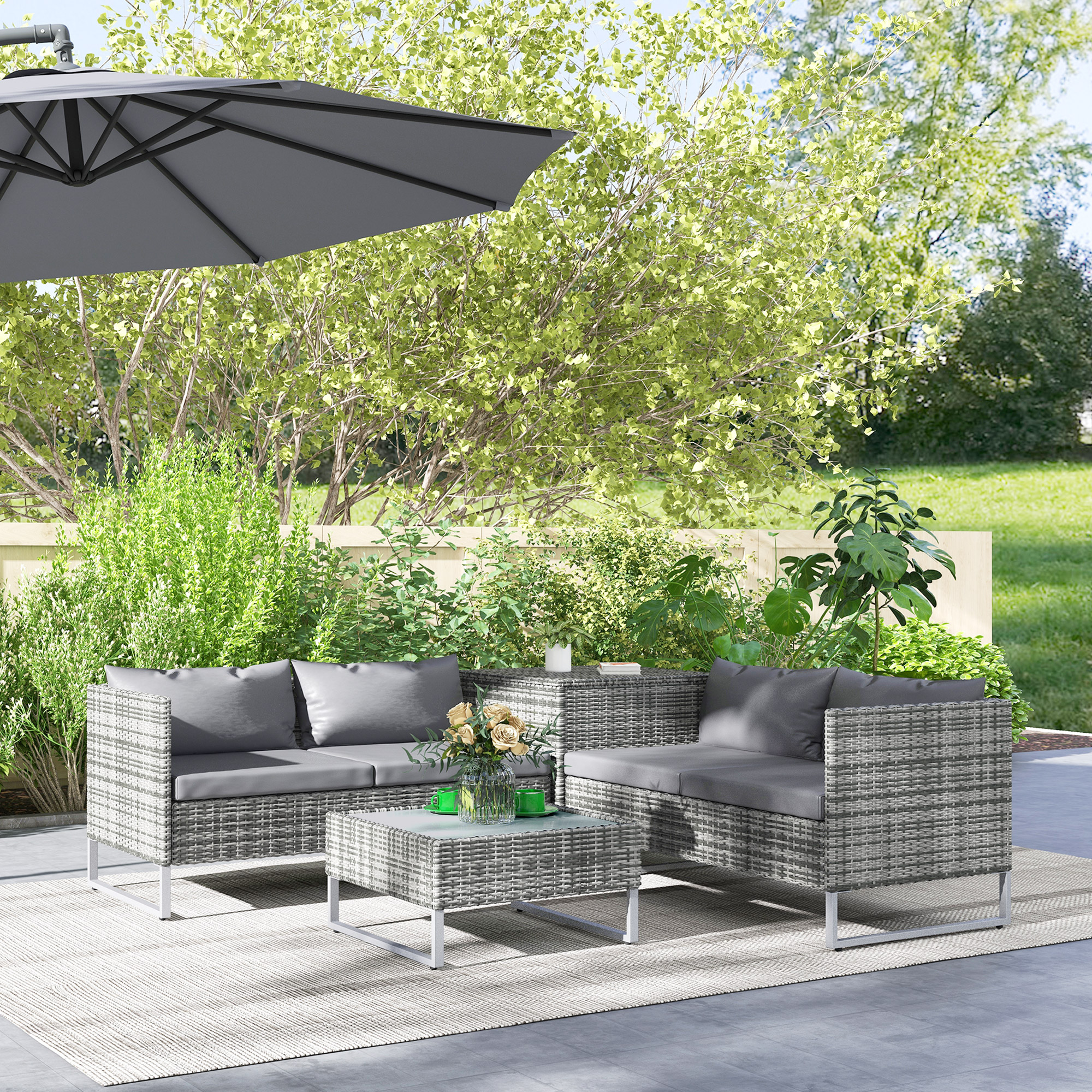 Arredamento da esterno in rattan grigio con tavolino sotto ombrellone.